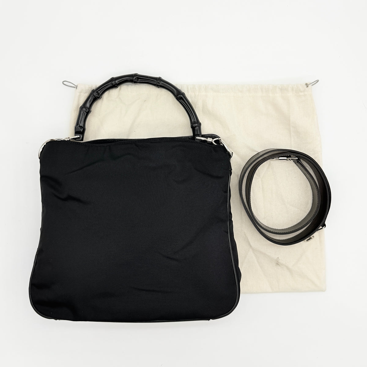 Gucci black nylon shoulder bag with bamboo handle and detachable strap shown with dust bag.
