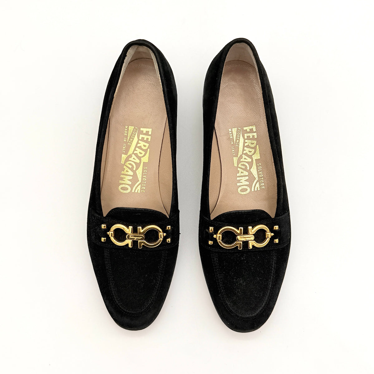 Salvatore Ferragamo black suede loafers with gold Gancini horsebit detail, displayed side by side on a white background.