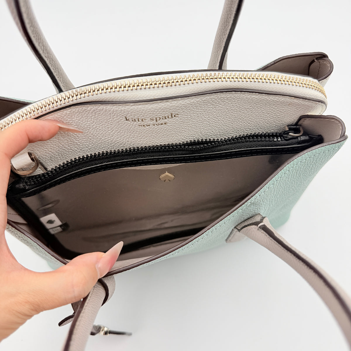 Kate Spade New York Margaux satchel in mint green pebbled leather with taupe handles, shown with its detachable strap and a clear pouch.