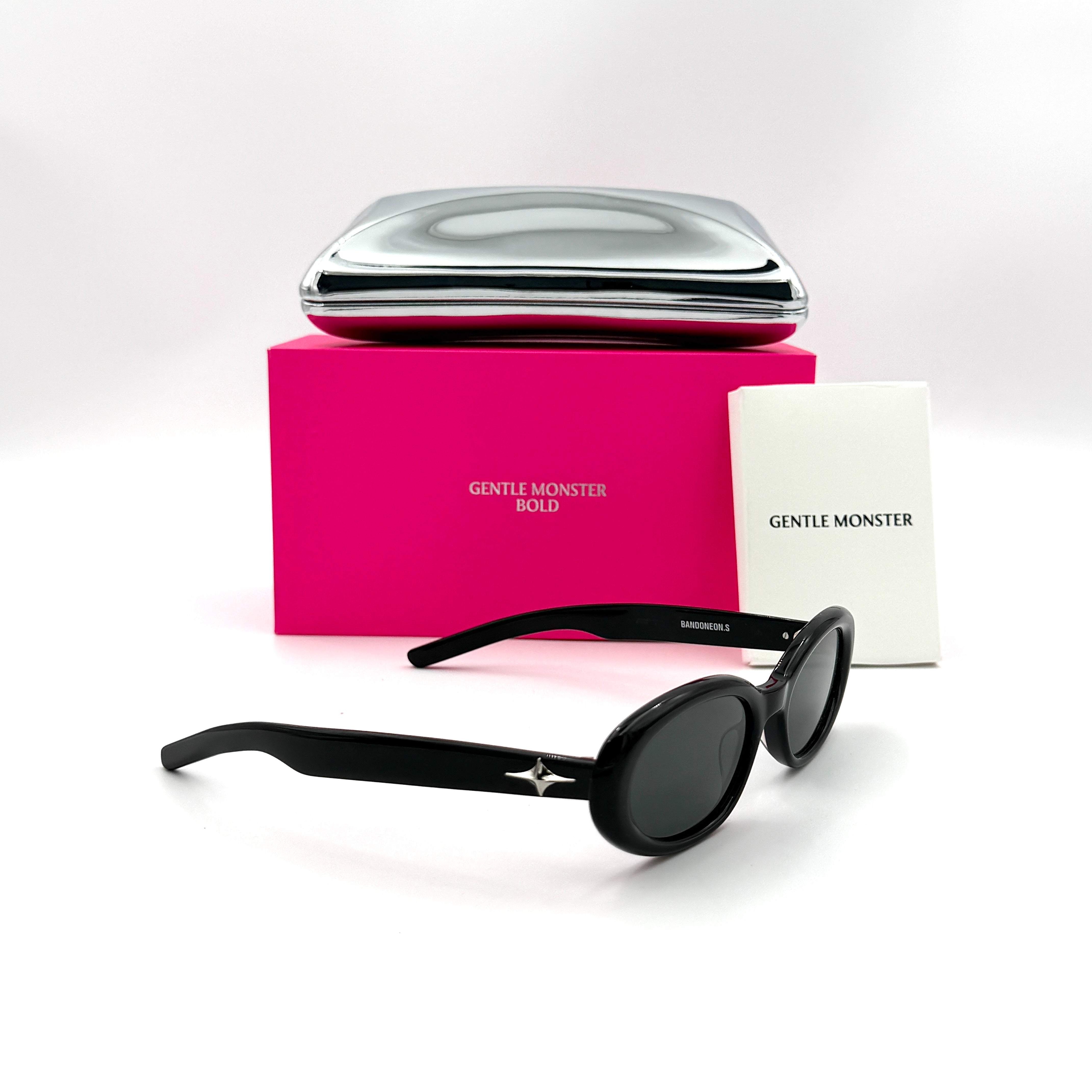 Gentle Monster Bandoneon.S sunglasses in black acetate with dark oval lenses and silver star accents shown from the side.