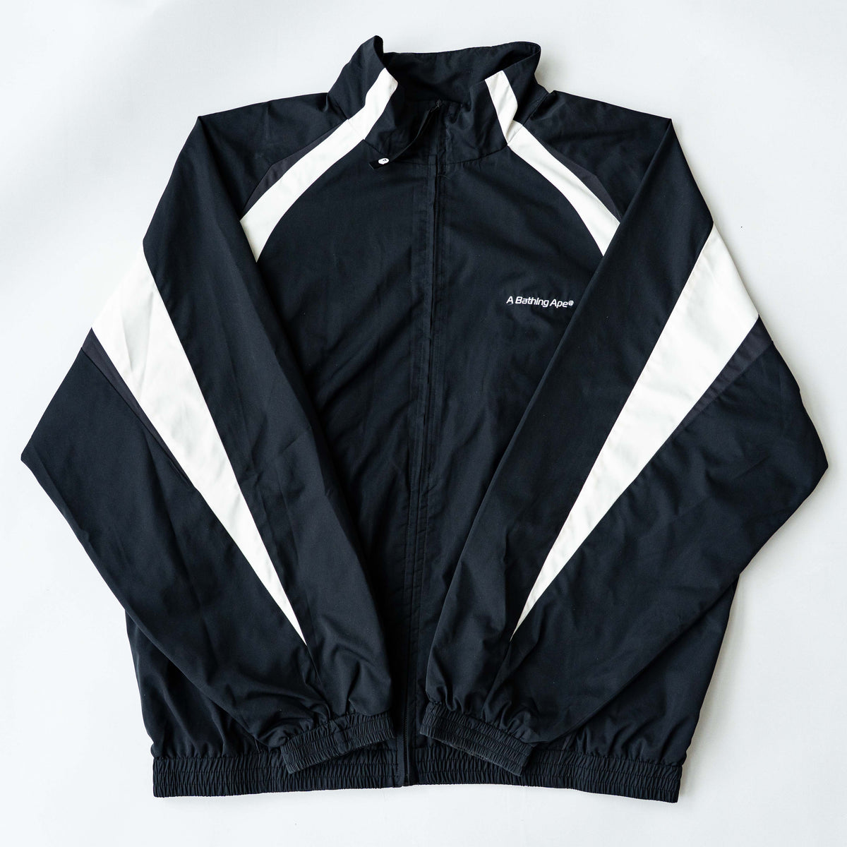 BAPE A Bathing Ape black and white logo track jacket with bold panel detailing, shown laid flat.
