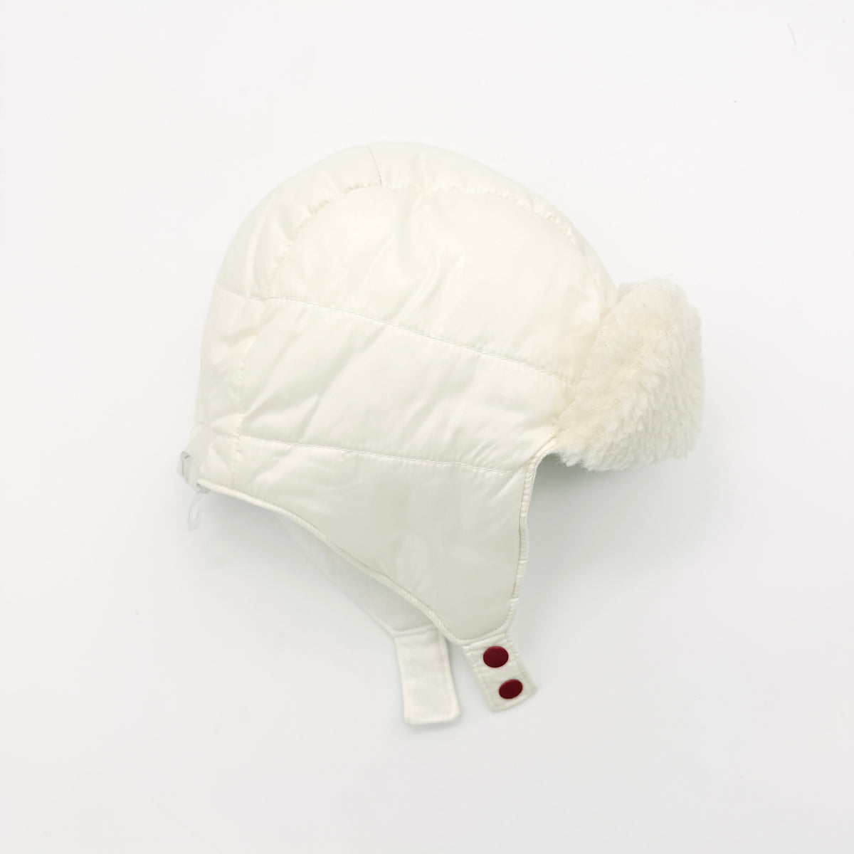 Moncler ivory quilted trapper hat with plush faux fur trim and signature logo patch displayed on white background.