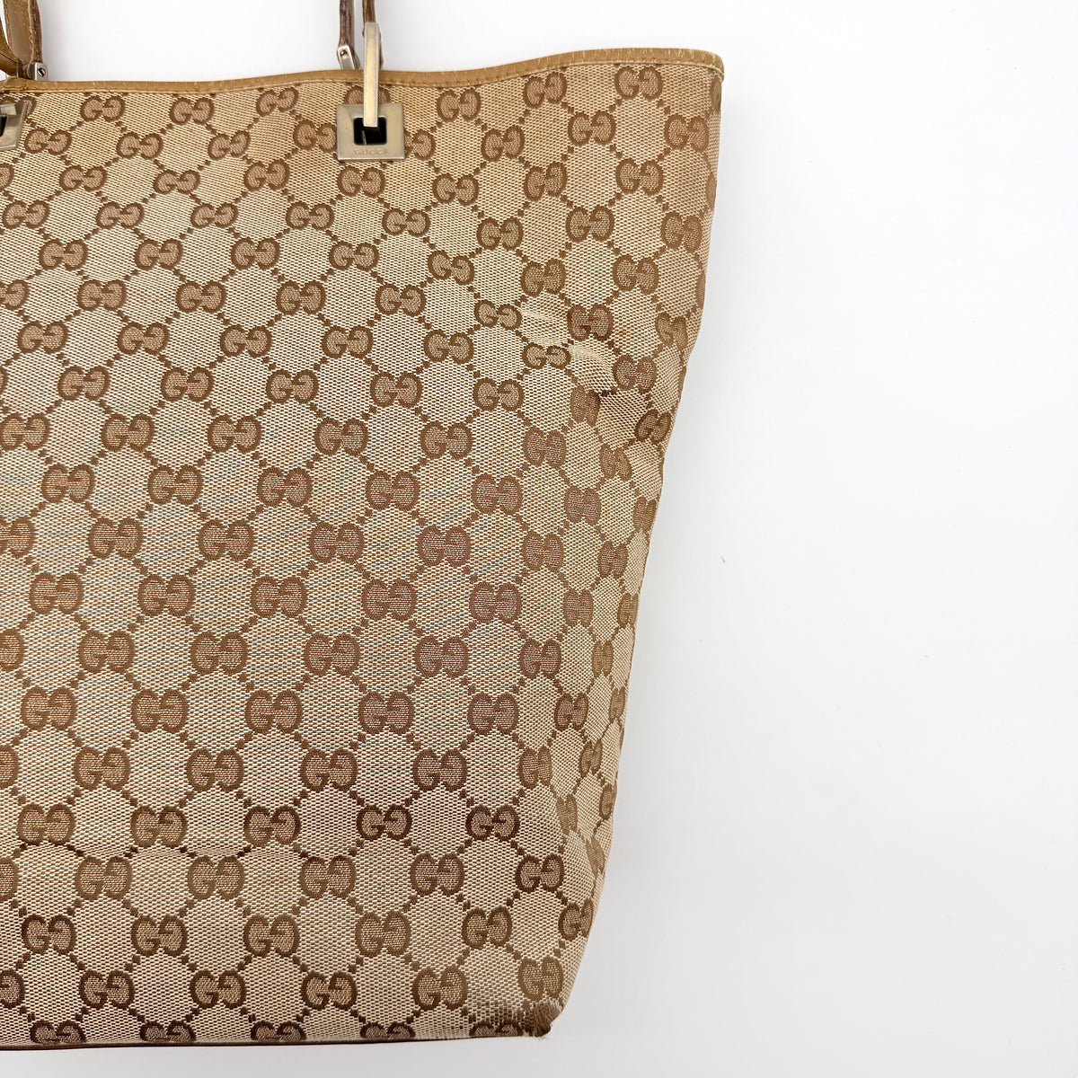 Front-facing Gucci GG Monogram Tote Bag in beige canvas with brown leather trim and double handles.