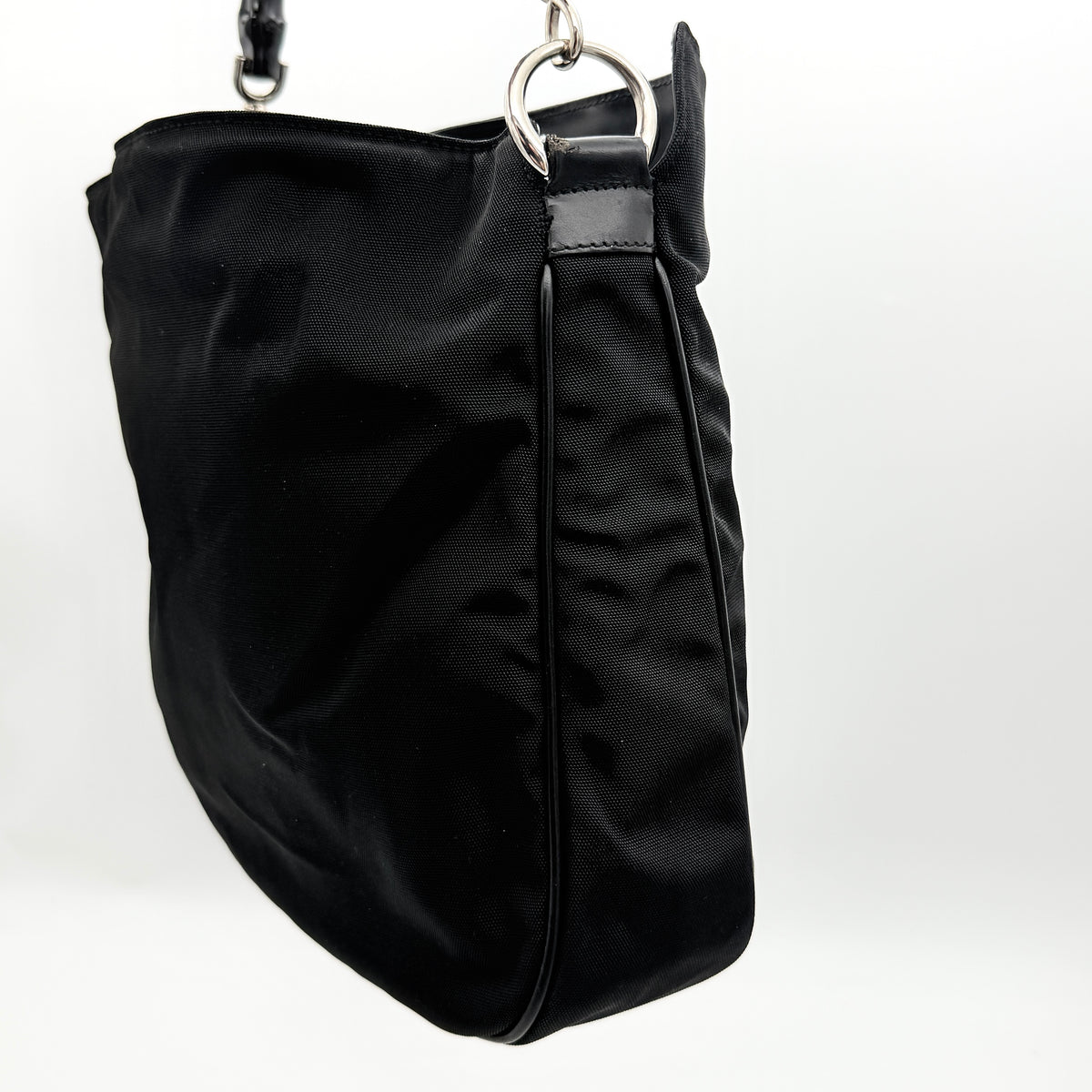 Gucci black nylon shoulder bag with bamboo handle and detachable strap shown with dust bag.