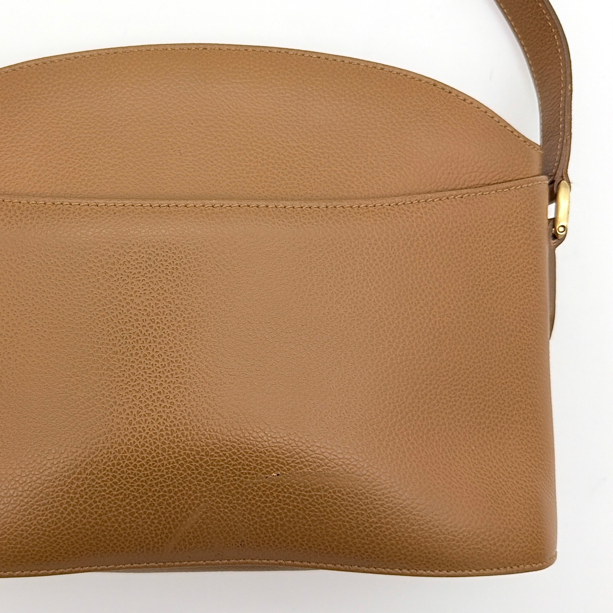 Coach tan leather crossbody bag with gold-tone hardware and adjustable strap, photographed on a white background.