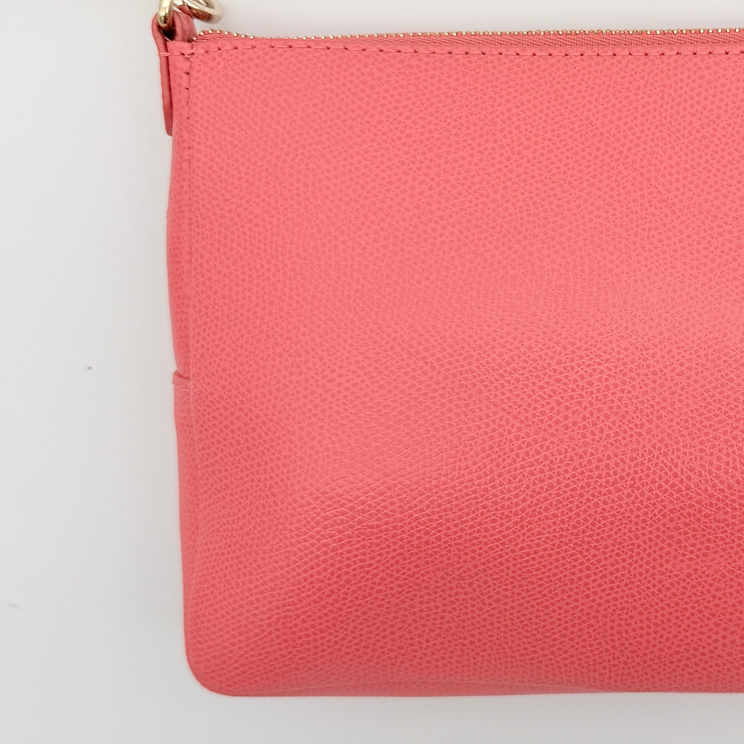 Furla pink leather crossbody bag with gold zip and adjustable strap, photographed flat on a white background.