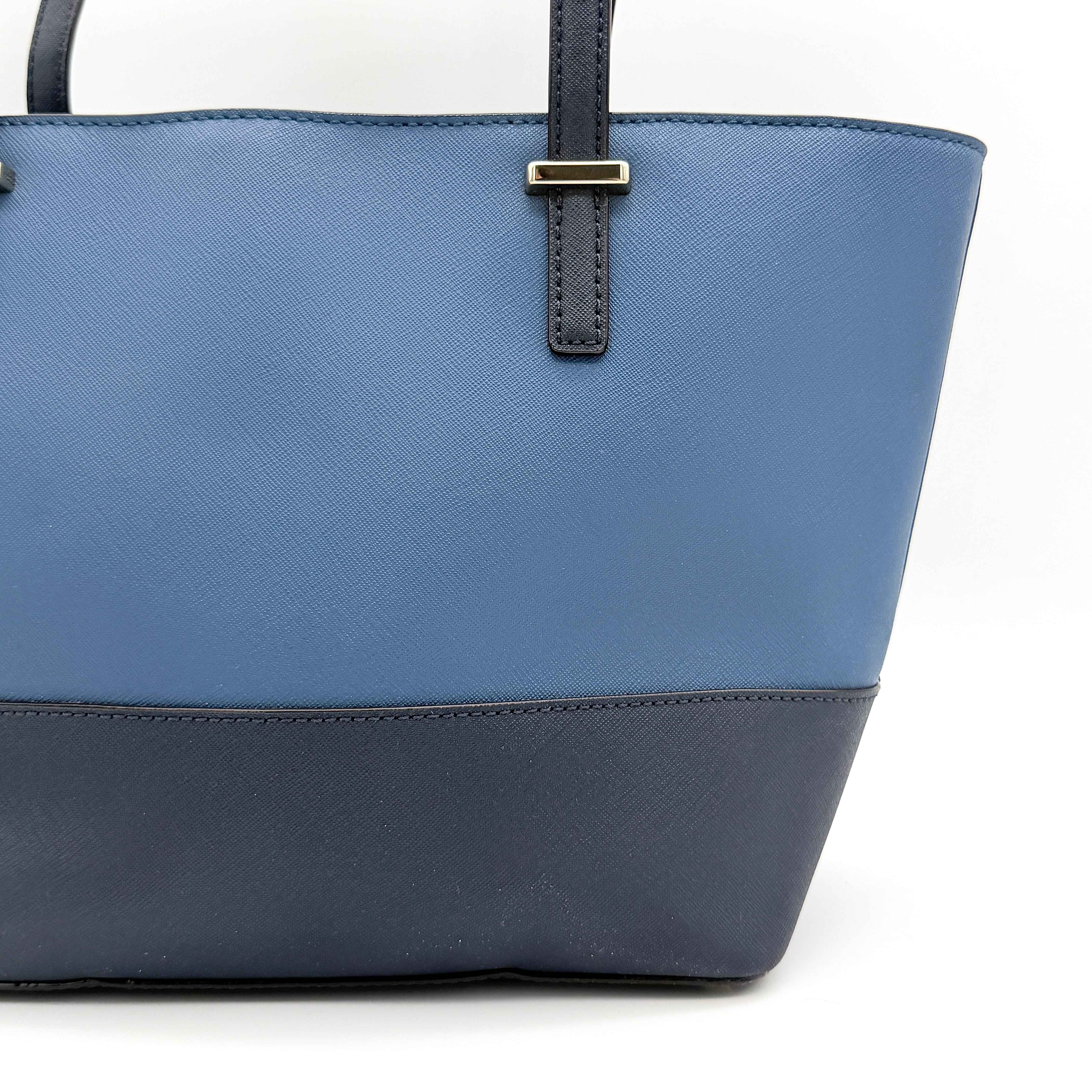 Kate Spade New York leather tote in two-tone blue with gold-tone hardware and structured handles.