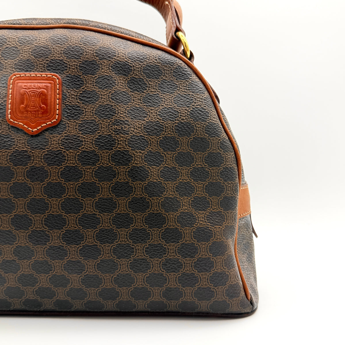 Front view of the Celine Triomphe Macadam Dome Handbag in brown, featuring the signature monogram canvas and tan leather details.