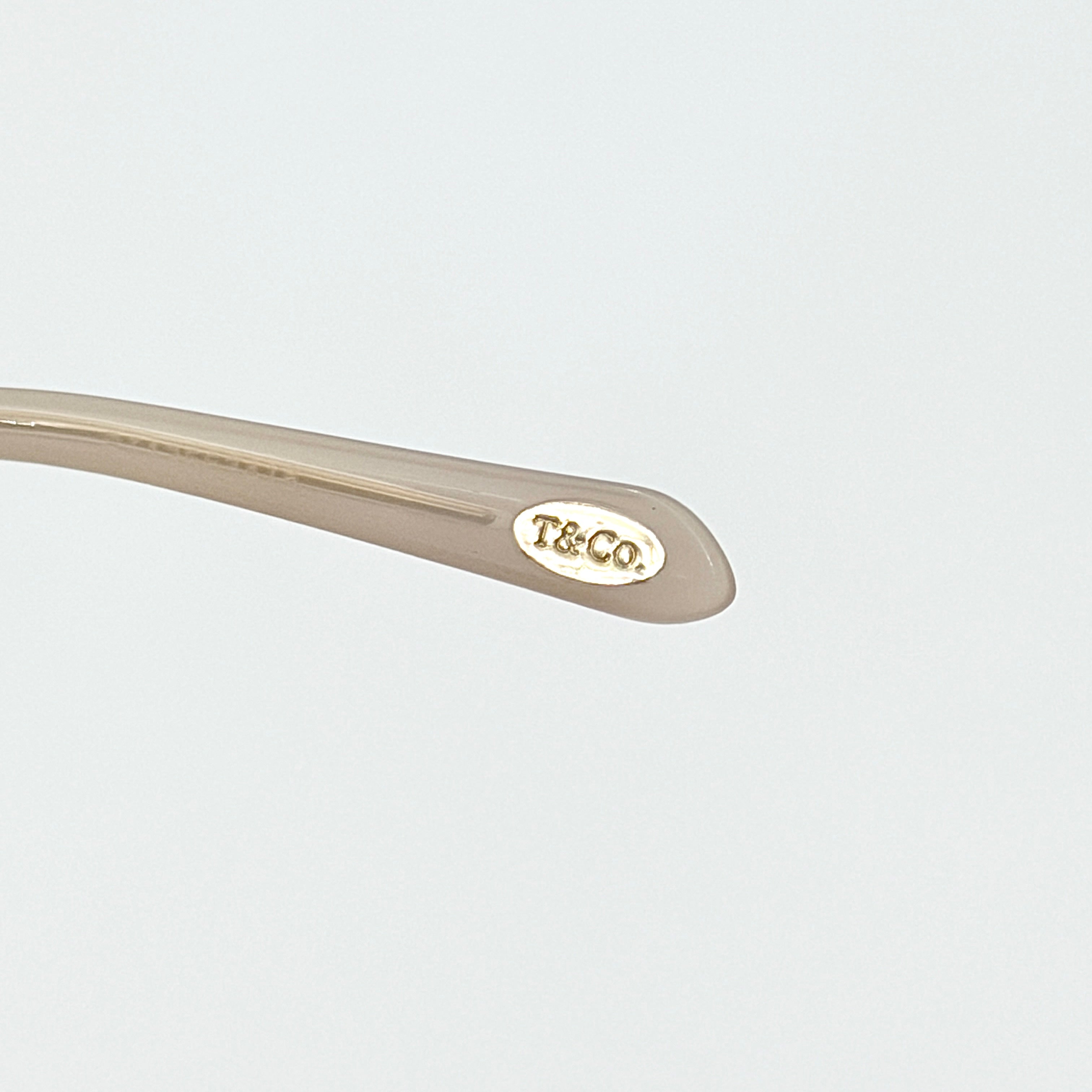 Tiffany & Co. TF4144 sunglasses in pink with gold-tone knot detail arms, shown with signature blue case.