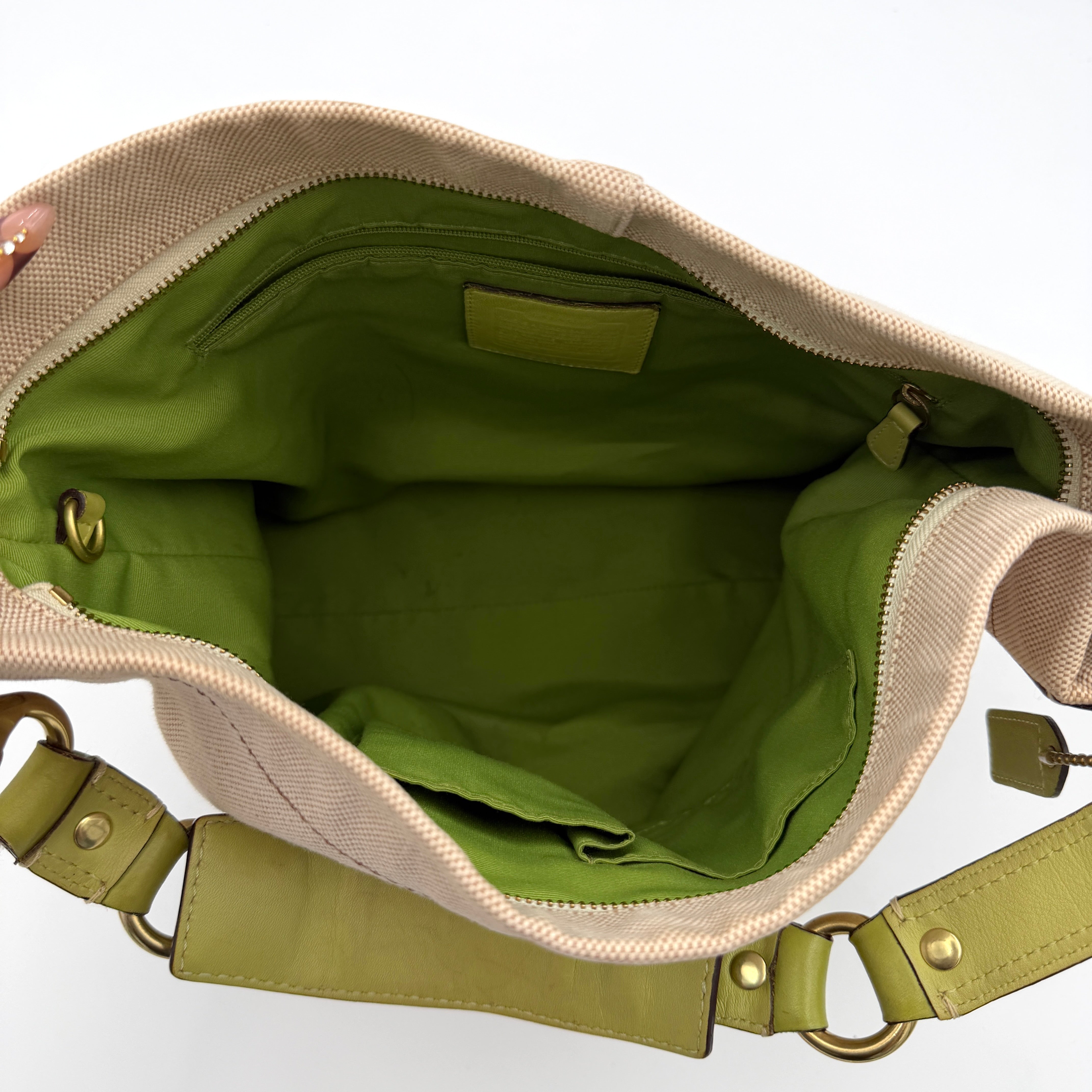 Coach Carly Hobo Shoulder Bag in beige canvas with green leather trim and gold hardware, shown on a white background.