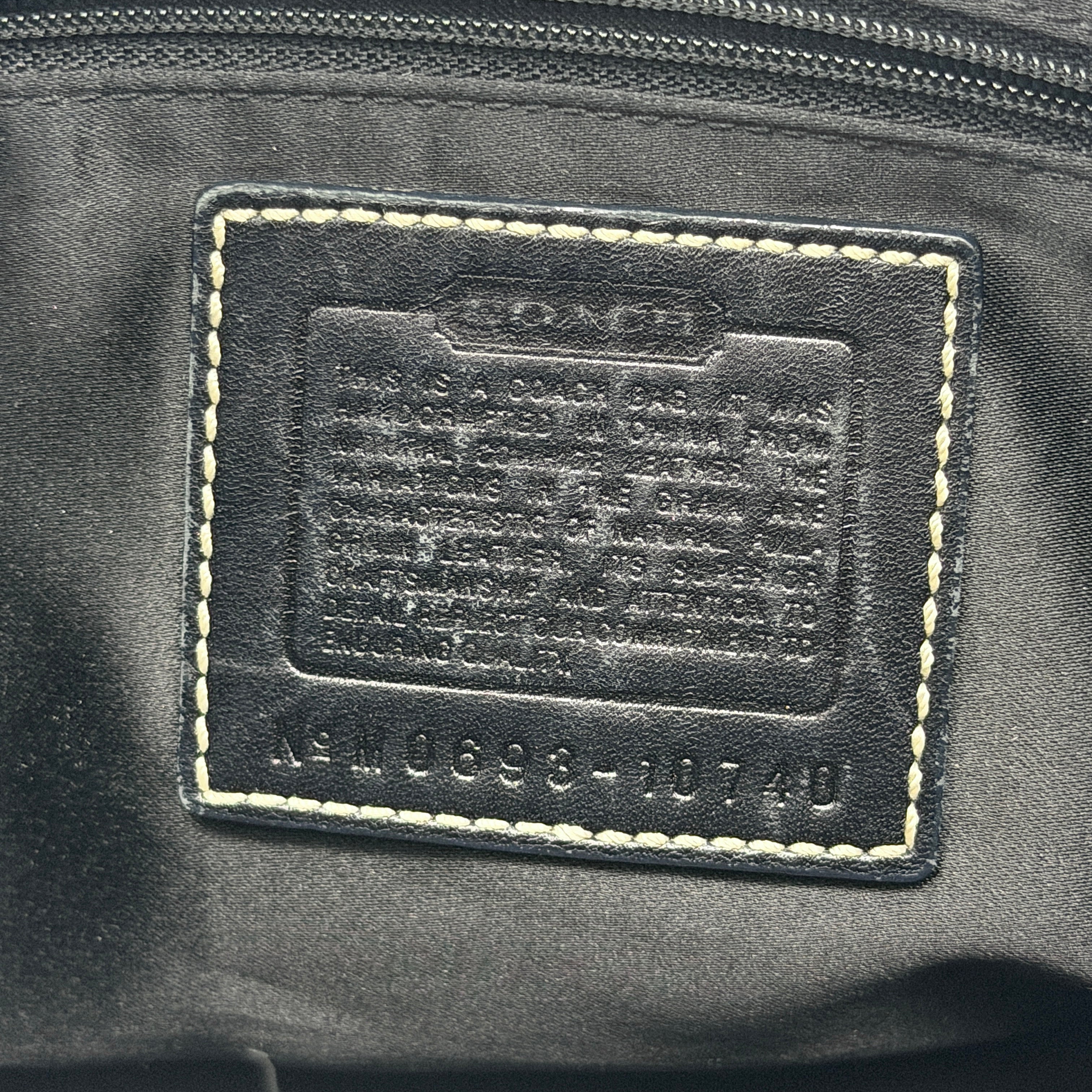 Coach Signature Ergo Hobo Shoulder Bag in black leather with contrast stitching and brass hardware, displayed against a white background.