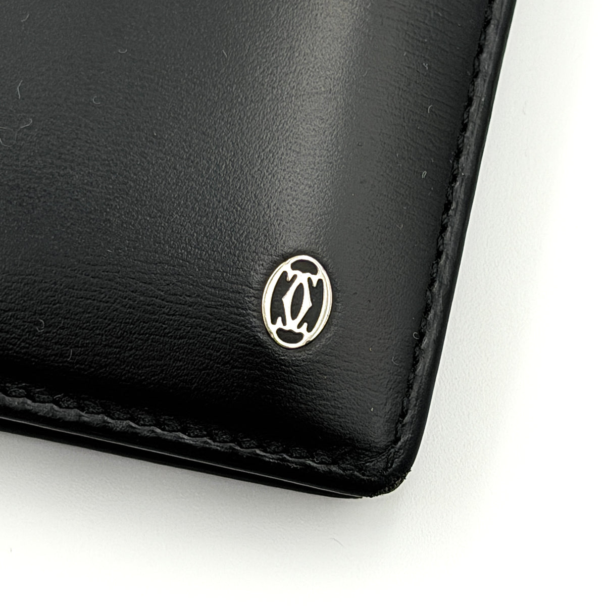 Cartier Must de Cartier black leather bifold wallet, shown with its signature red box and authentication card.