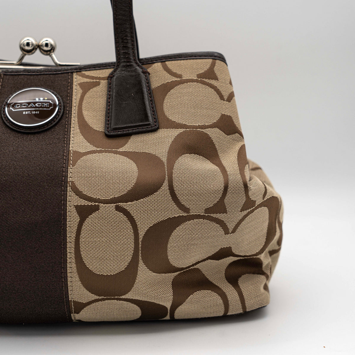 Coach Signature Stripe Frame Kisslock Shoulder Bag in beige and brown canvas with leather trim and signature monogram pattern.