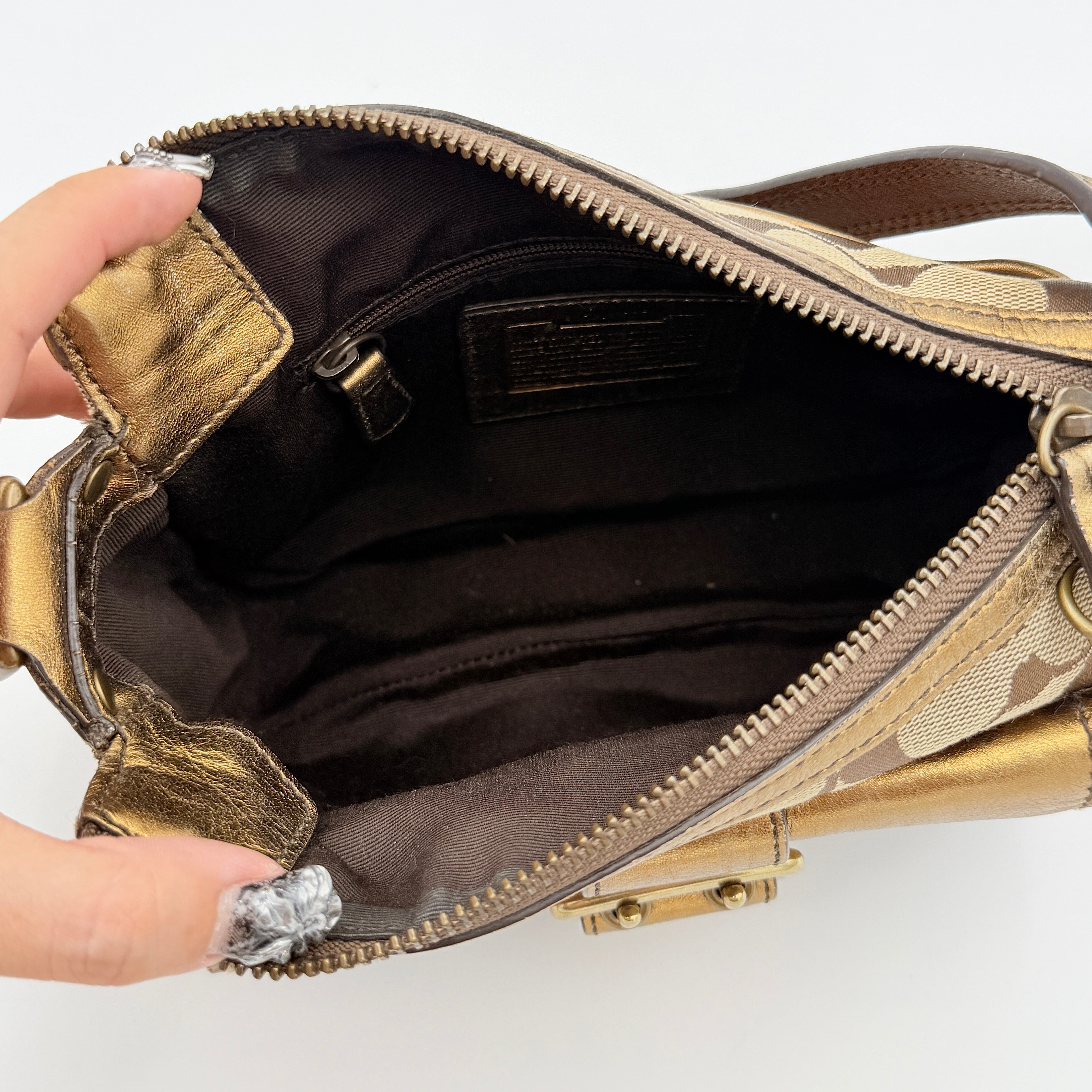 Coach Signature shoulder bag in beige jacquard with gold leather front flap, showcased on a plain background.