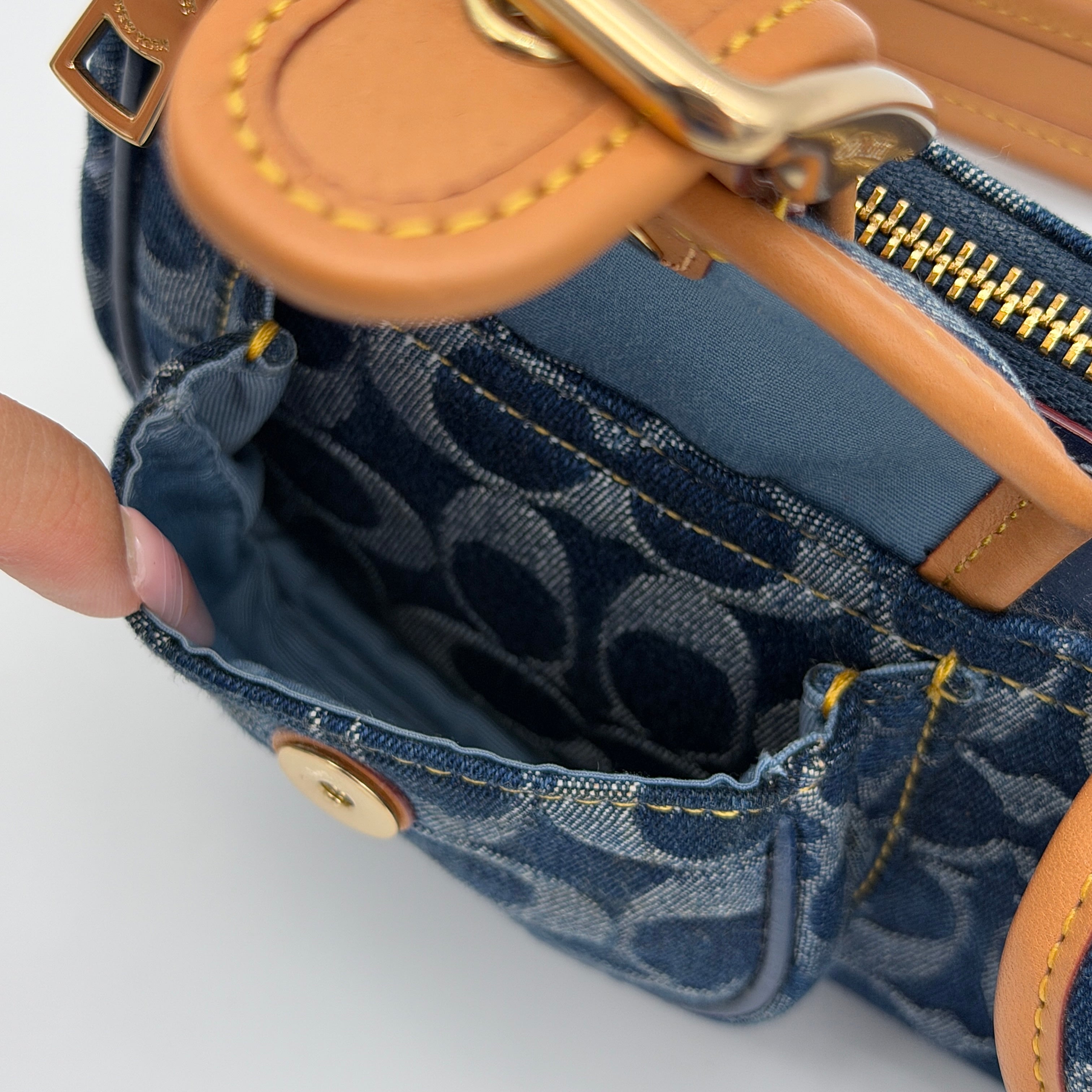 Coach Signature Ashton shoulder bag in blue denim and tan leather with gold hardware, shown with removable strap and dust bag.
