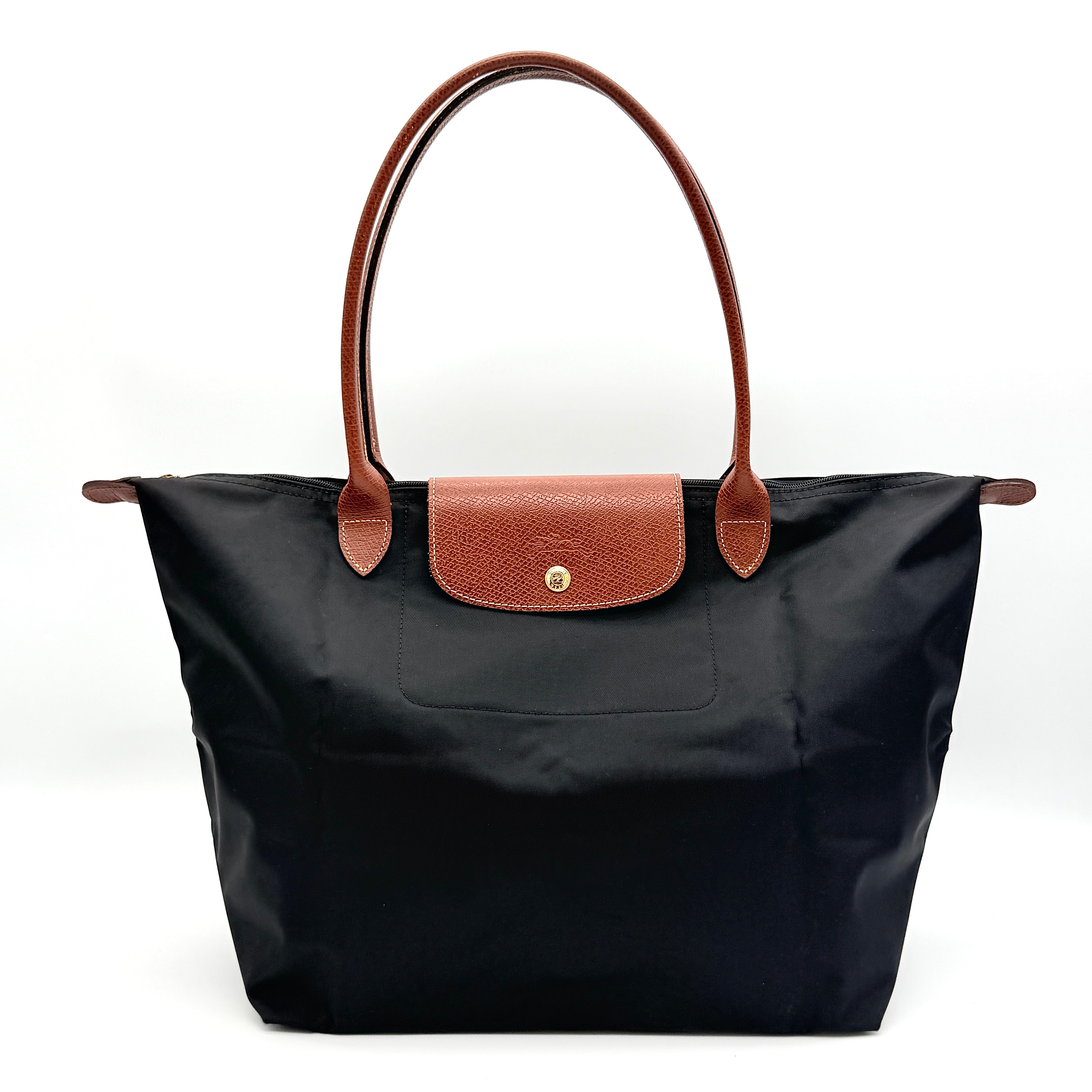 Longchamp Le Pliage Original Tote Bag in black with brown leather handles and flap, photographed against a white background.