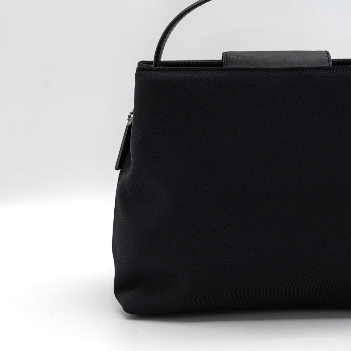 Coach Mercer tote bag in black nylon with leather handle and trim, presented against a white background.