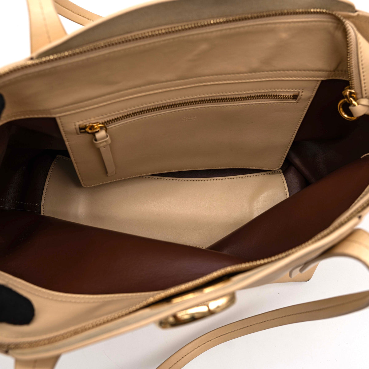 Chloé C Zipped Tote Bag in beige leather with gold hardware, shown with structured dual straps and front logo detail.