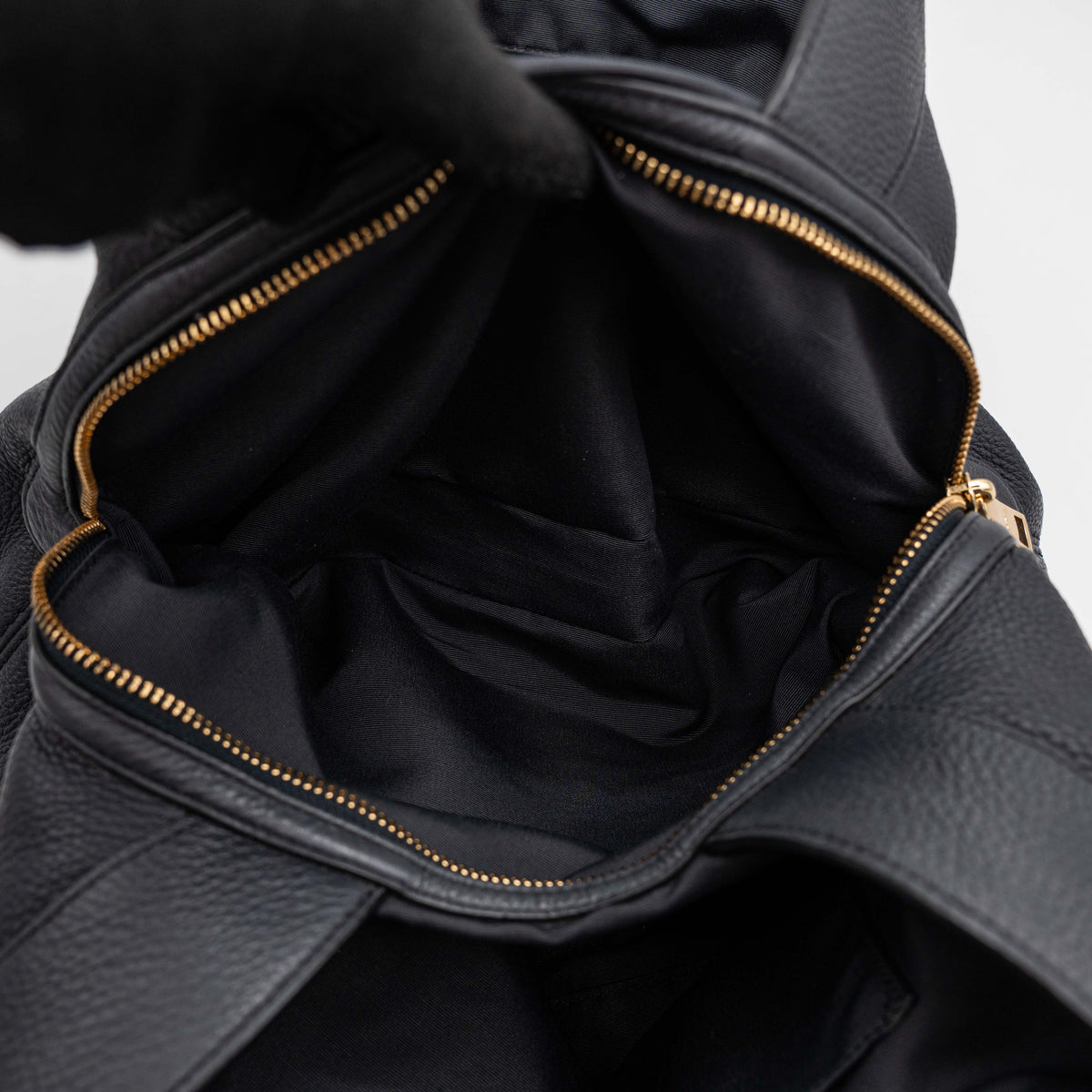 Coach Lexy Shoulder Bag in black pebbled leather with gold-tone hardware and double handles, styled against a white background.