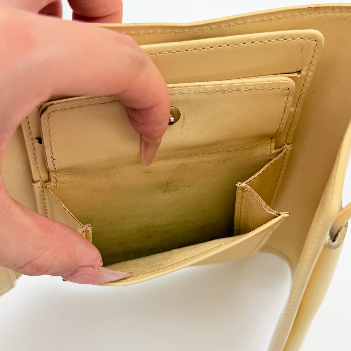 Louis Vuitton Epi Portefeuille Élastique Trifold Wallet in Vanilla Cream with dust bag, presented against a clean white background.