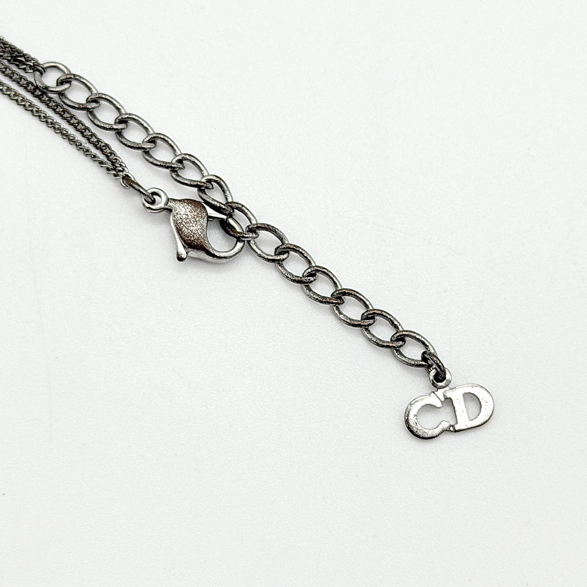 Christian Dior silver double chain bracelet with Dior logo medallion and adjustable clasp.