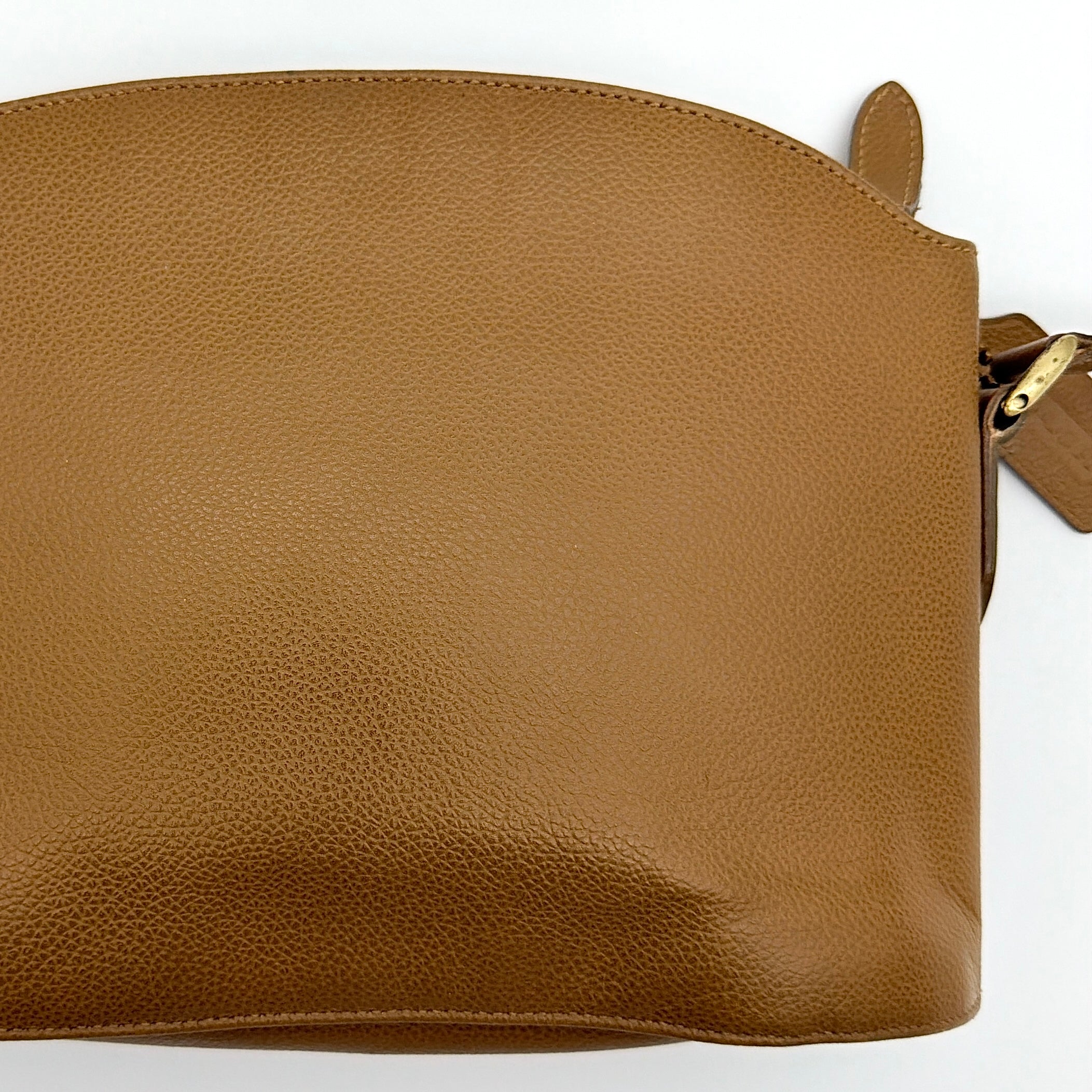 Coach tan leather crossbody bag with gold-tone hardware and adjustable strap, photographed on a white background.