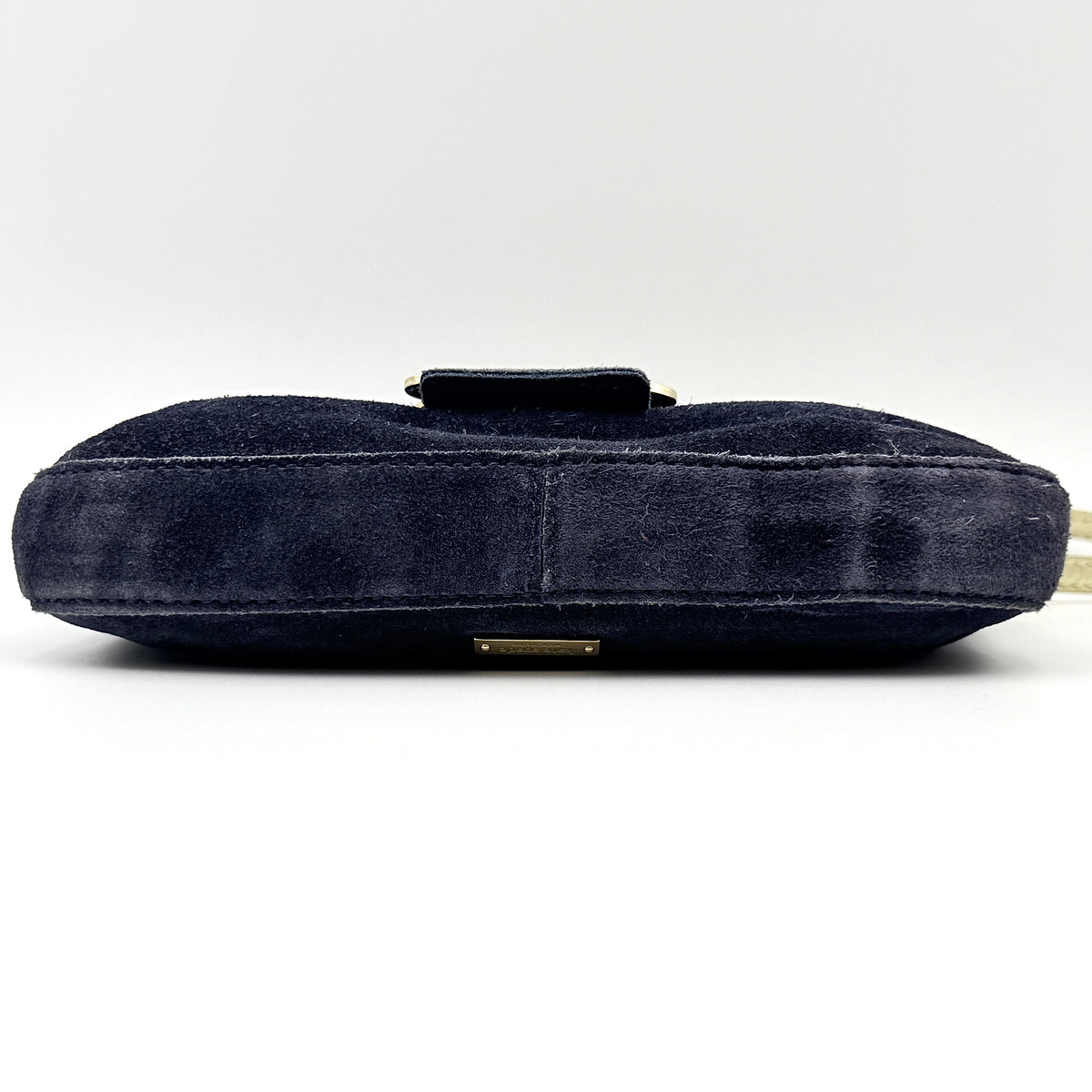 Navy blue suede Kate Spade baguette bag with floral gold hardware and gold-tone shoulder strap.