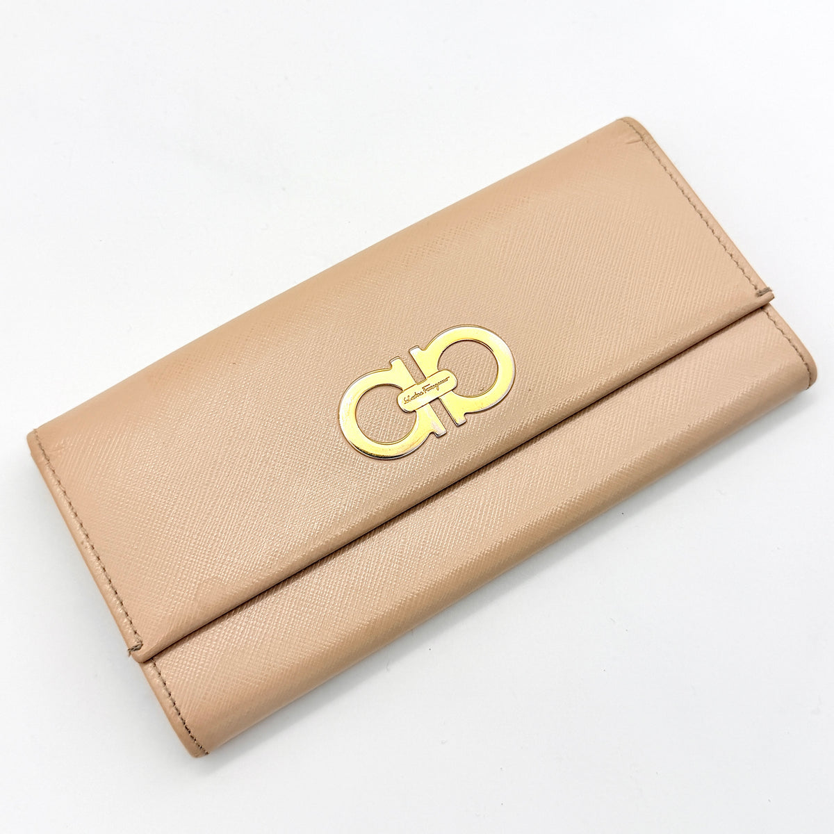 Salvatore Ferragamo light pink Saffiano wallet with gold Gancini hardware, shown on a white background.