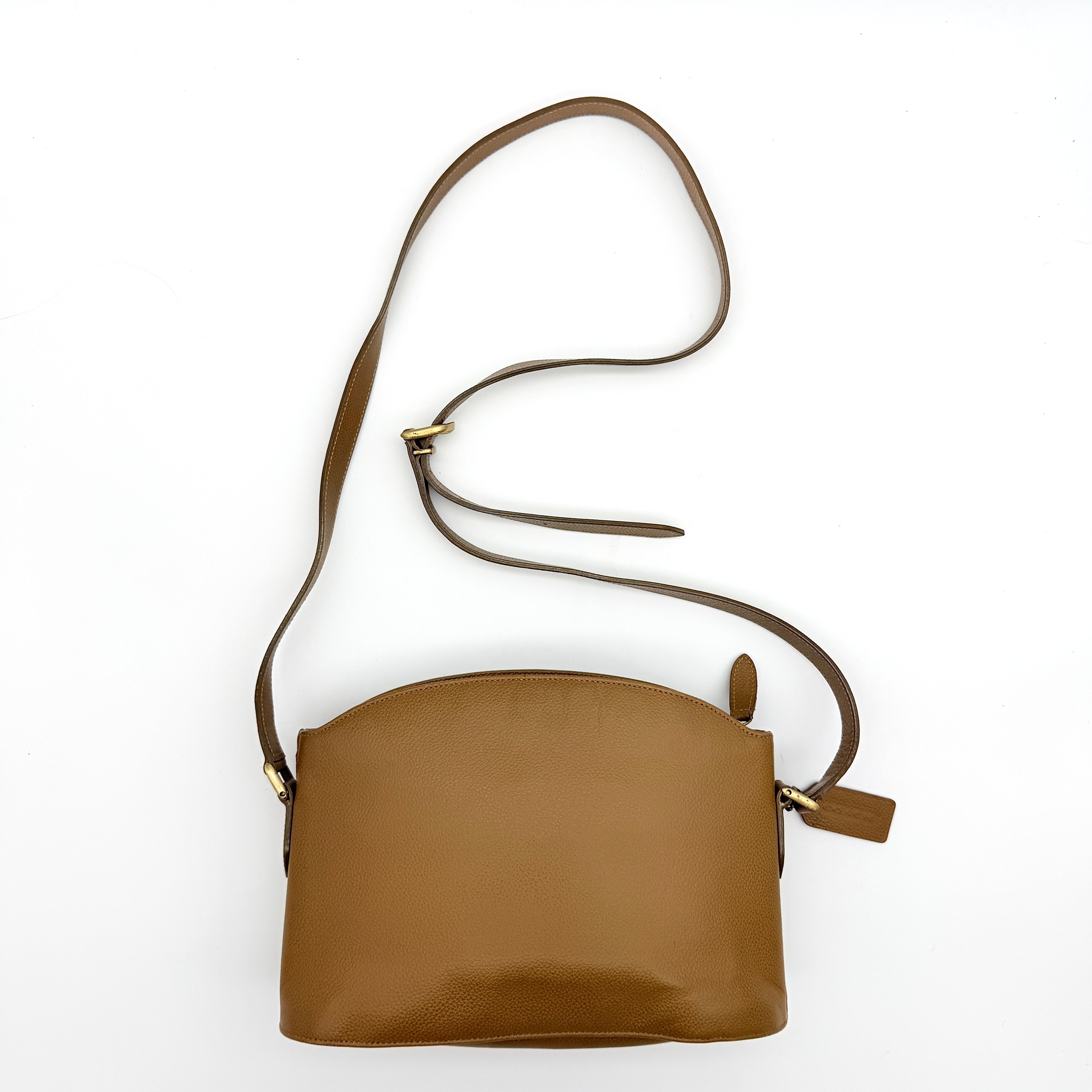 Coach tan leather crossbody bag with gold-tone hardware and adjustable strap, photographed on a white background.