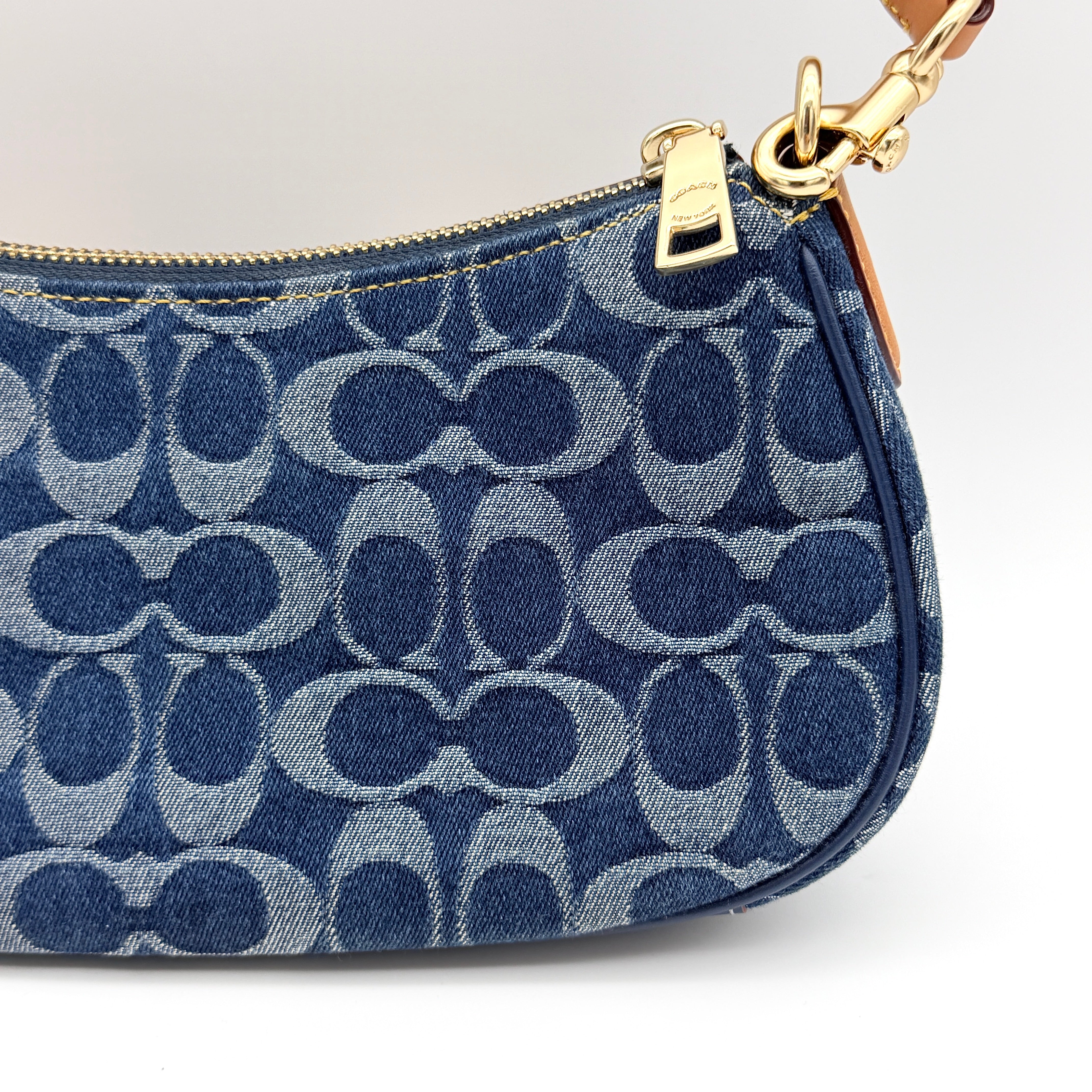 Coach Signature Ashton shoulder bag in blue denim and tan leather with gold hardware, shown with removable strap and dust bag.