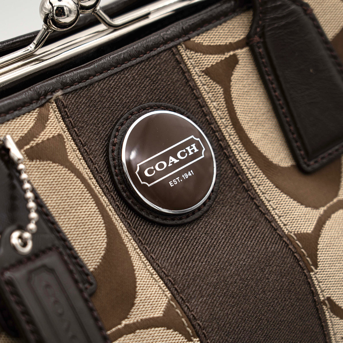 Coach Signature Stripe Frame Kisslock Shoulder Bag in beige and brown canvas with leather trim and signature monogram pattern.