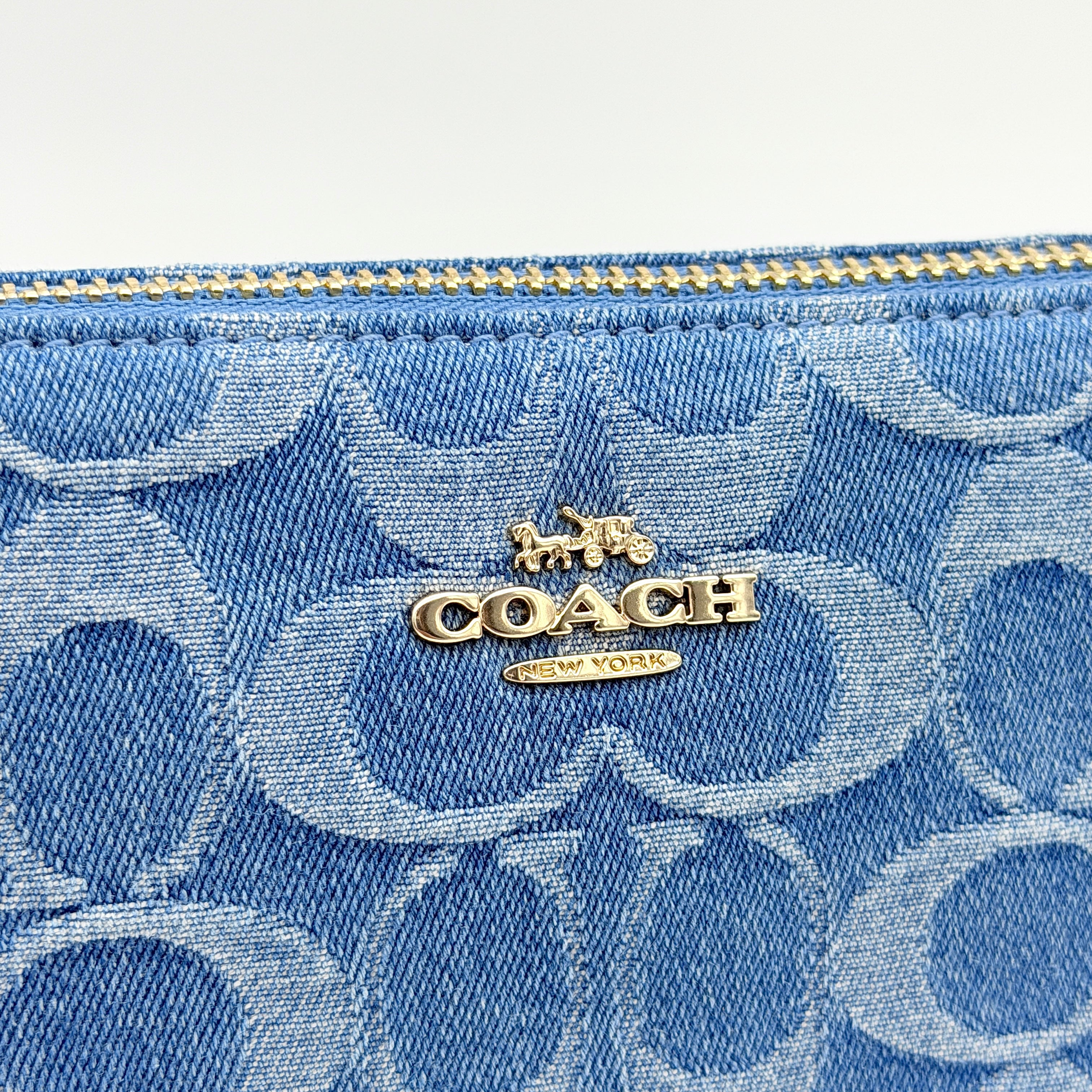 Coach Nolita 19 shoulder bag in blue denim jacquard with monogram print and gold hardware, shown with original packaging.