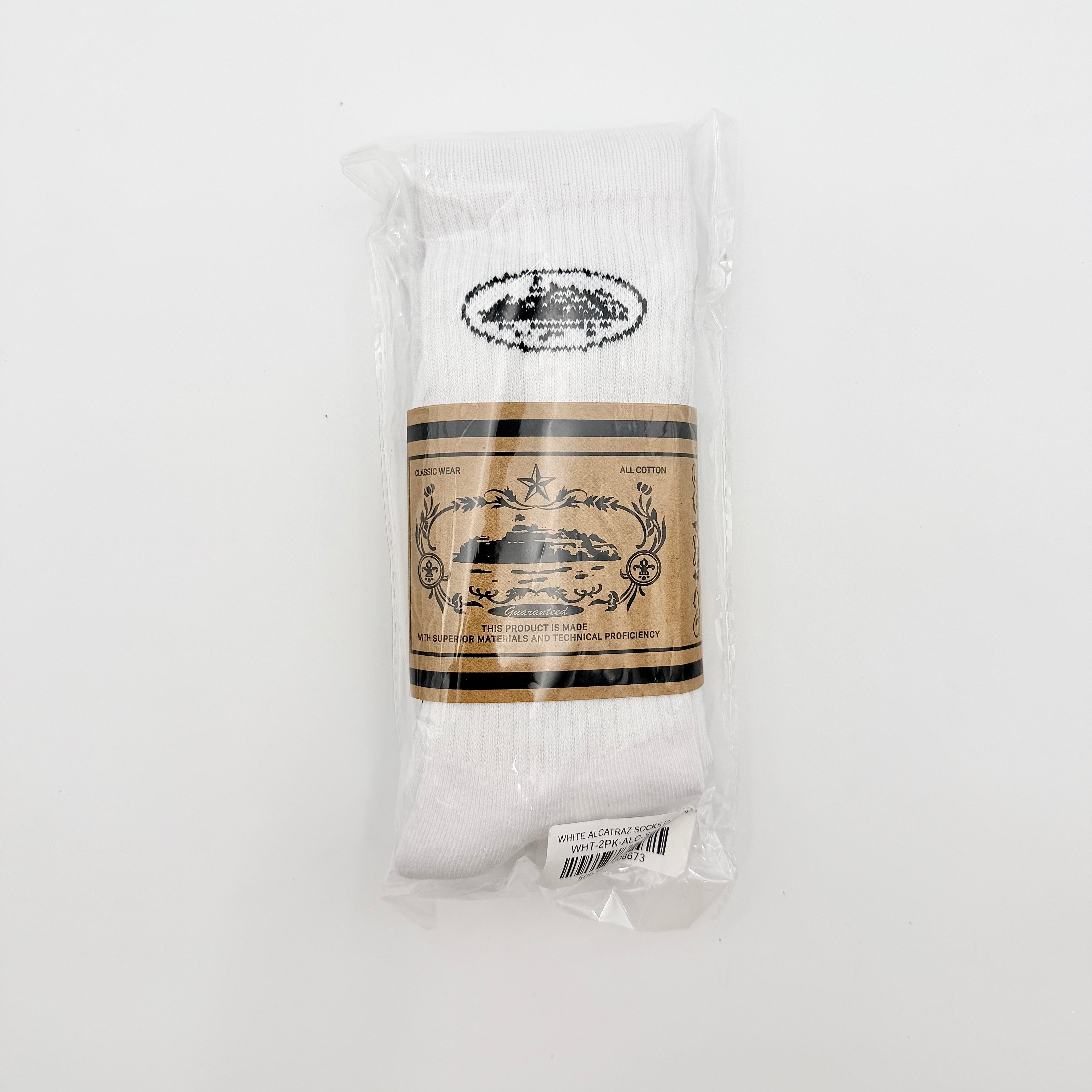 A pair of Corteiz Alcatraz white socks with black logo on the ankle and statement text on the sole.