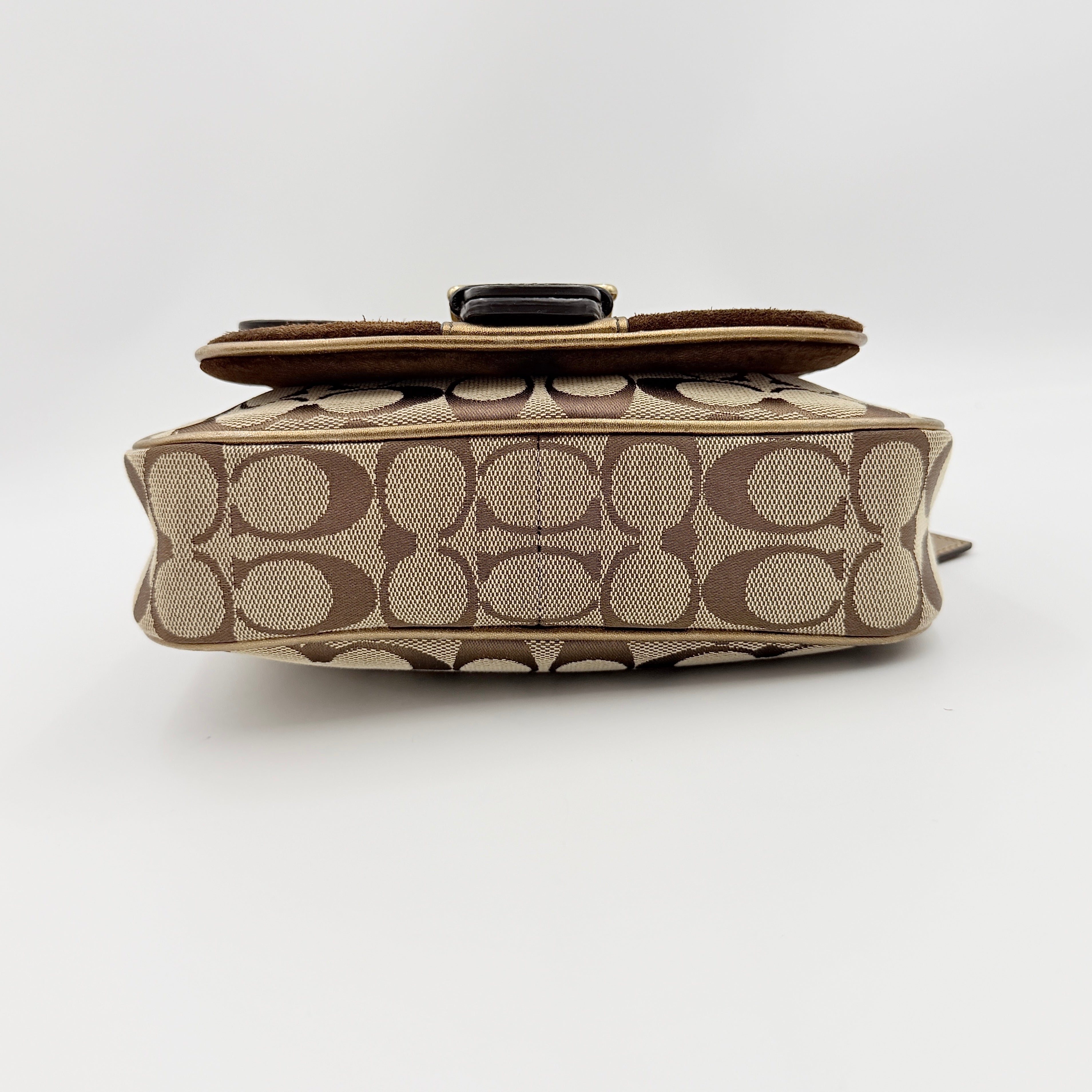 Coach Signature shoulder bag in beige jacquard with gold leather front flap, showcased on a plain background.