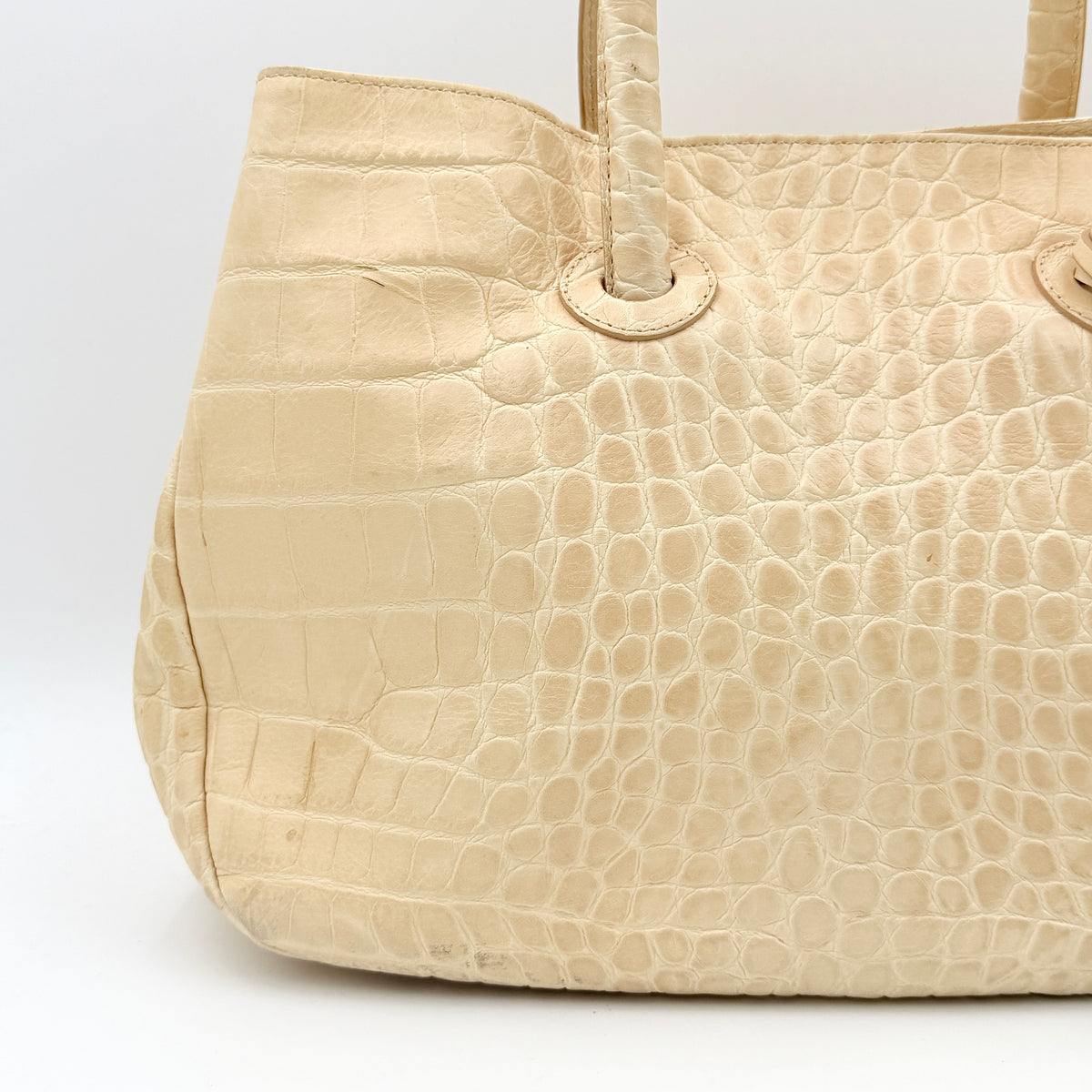 Furla beige croc-embossed leather handbag with double handles and silver-tone logo medallion, photographed on a white background.