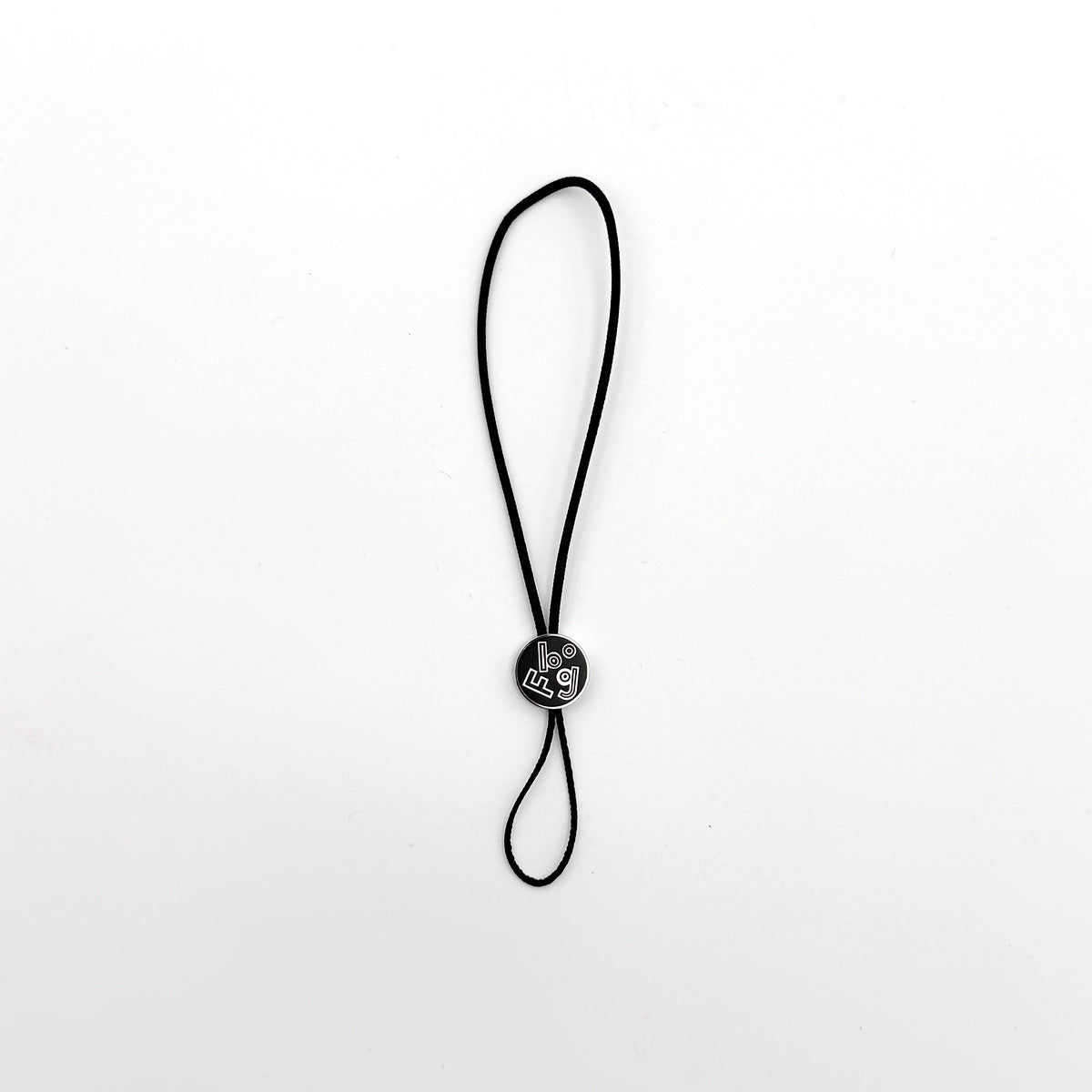 Hermès black cord cell phone charm strap with round silver-tone graphic accent, shown against a white background.