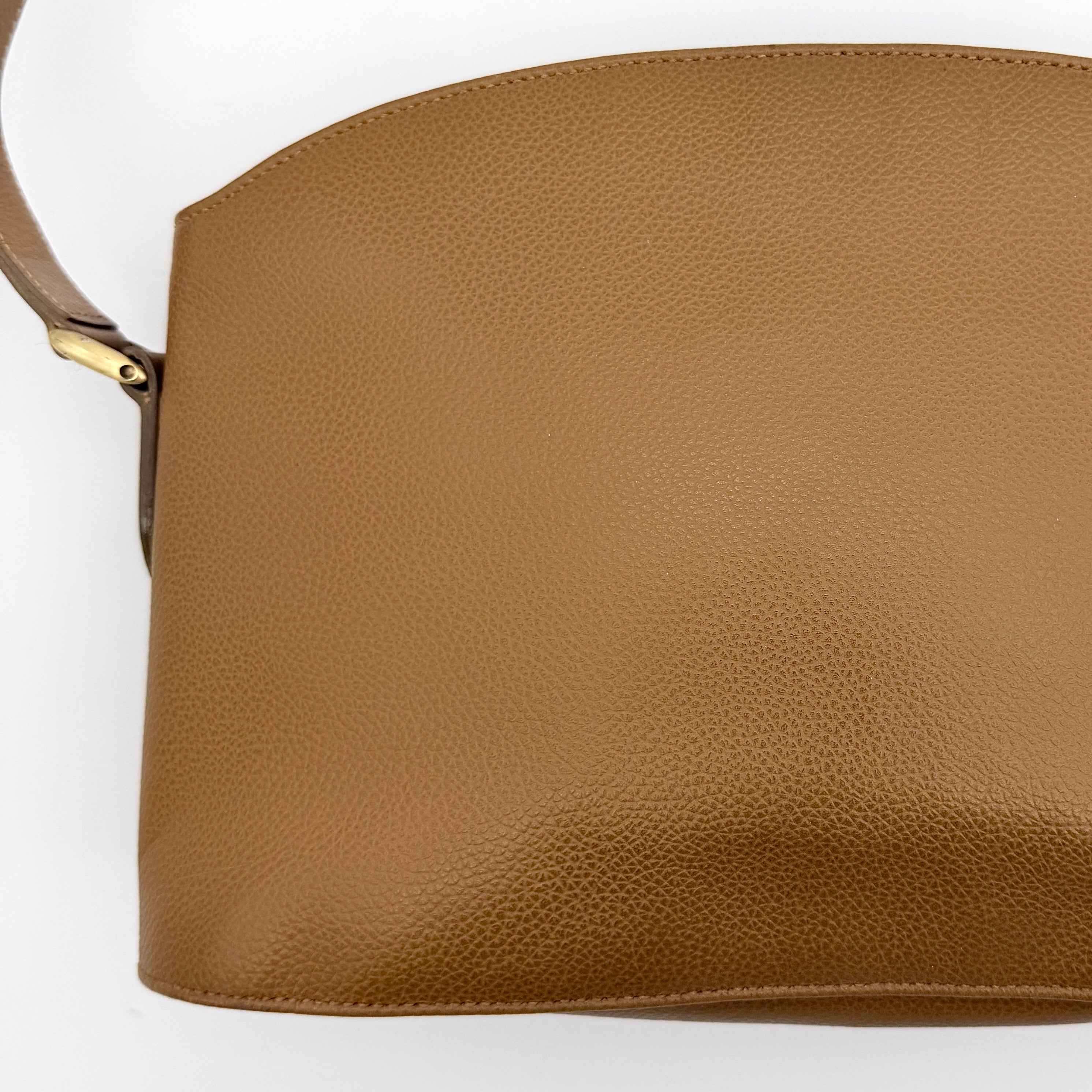 Coach tan leather crossbody bag with gold-tone hardware and adjustable strap, photographed on a white background.