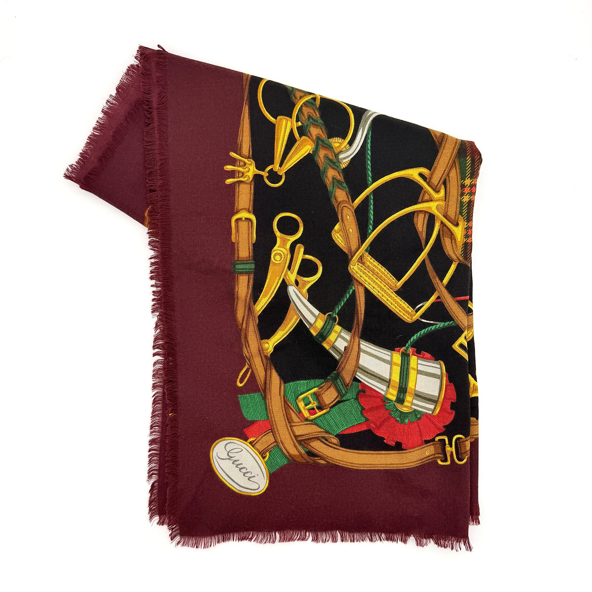 Gucci equestrian tartan shawl scarf in burgundy with heritage motifs and a fringed edge, styled folded.