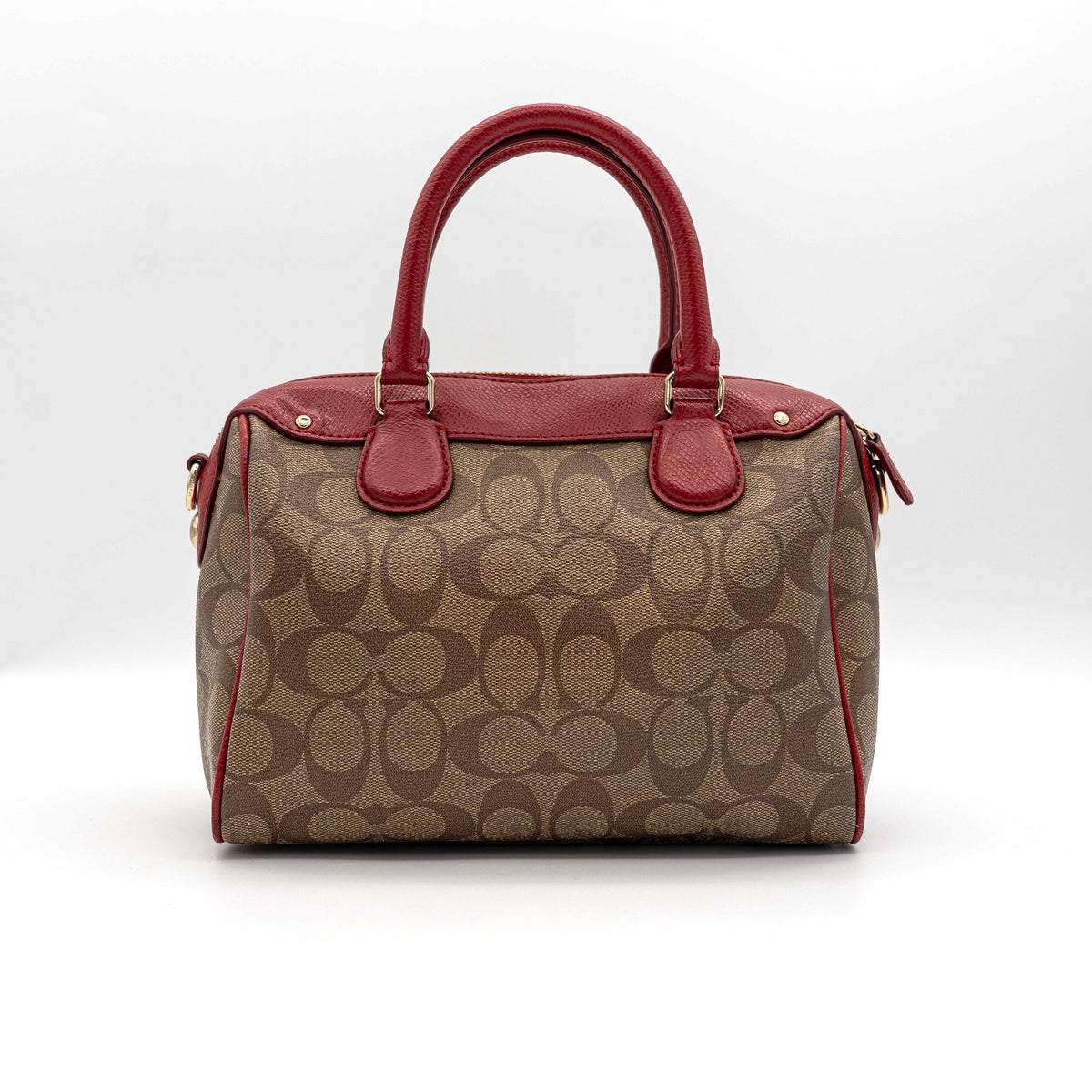 Coach Mini Bennett Boston bag in signature beige canvas with red leather trim, shown with detachable crossbody strap.