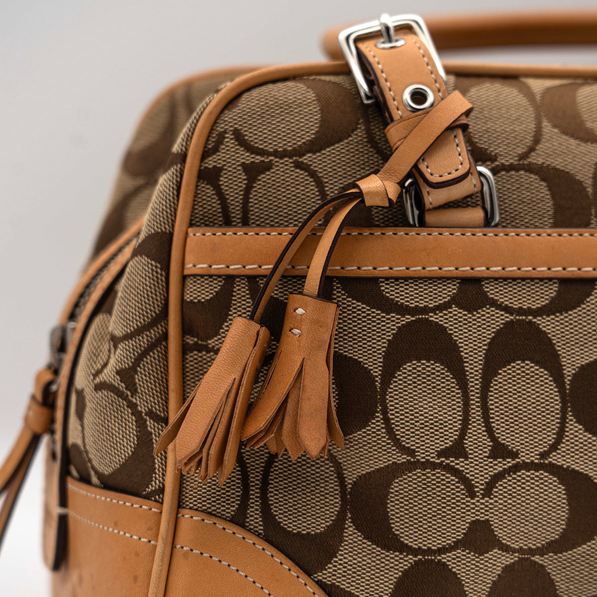 Coach Signature Hampton Satchel Boston Bag in beige and tan canvas with leather trim and silver hardware, styled on a clean background.