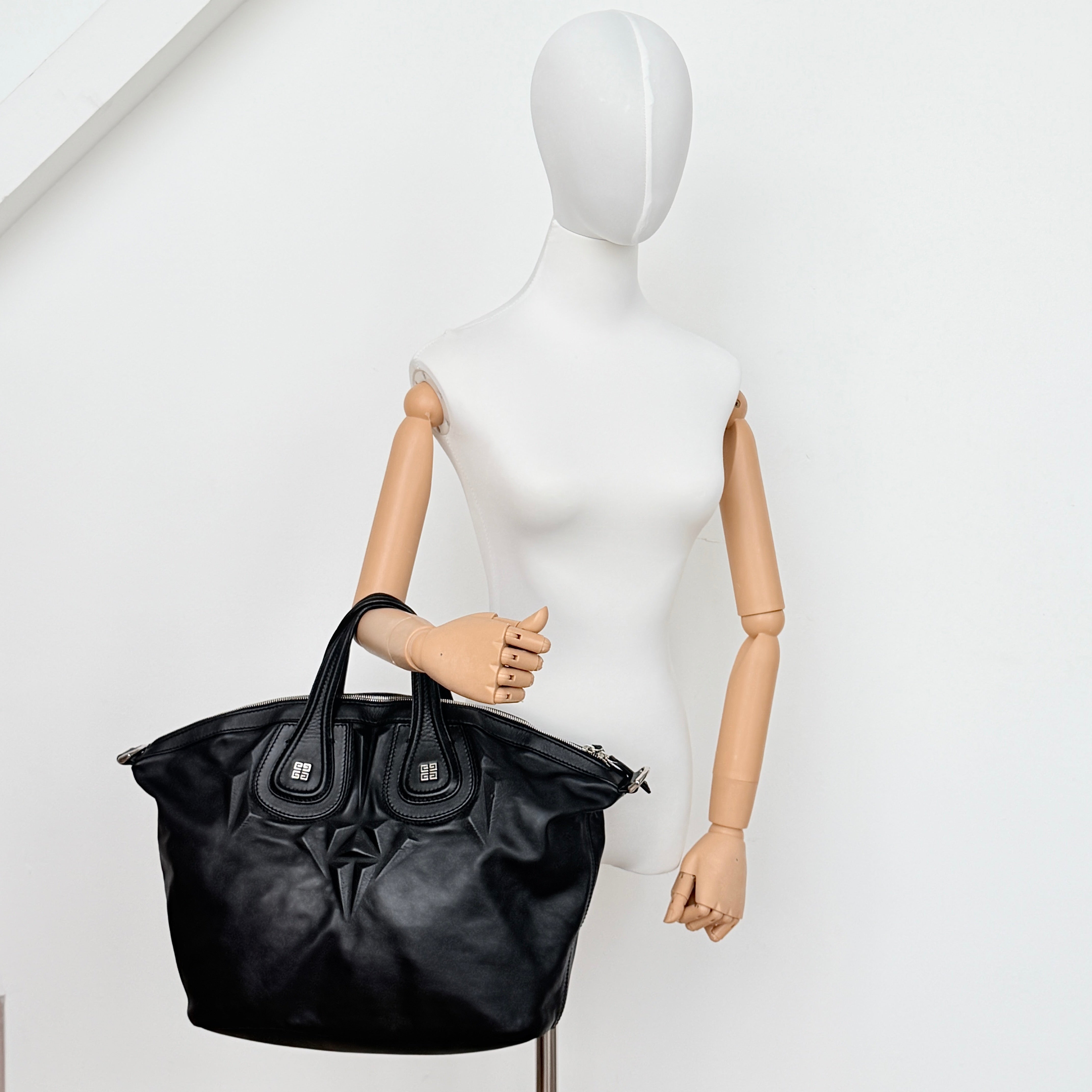Givenchy 2Way Nightingale Handbag in black leather with detachable strap and striking front motif.