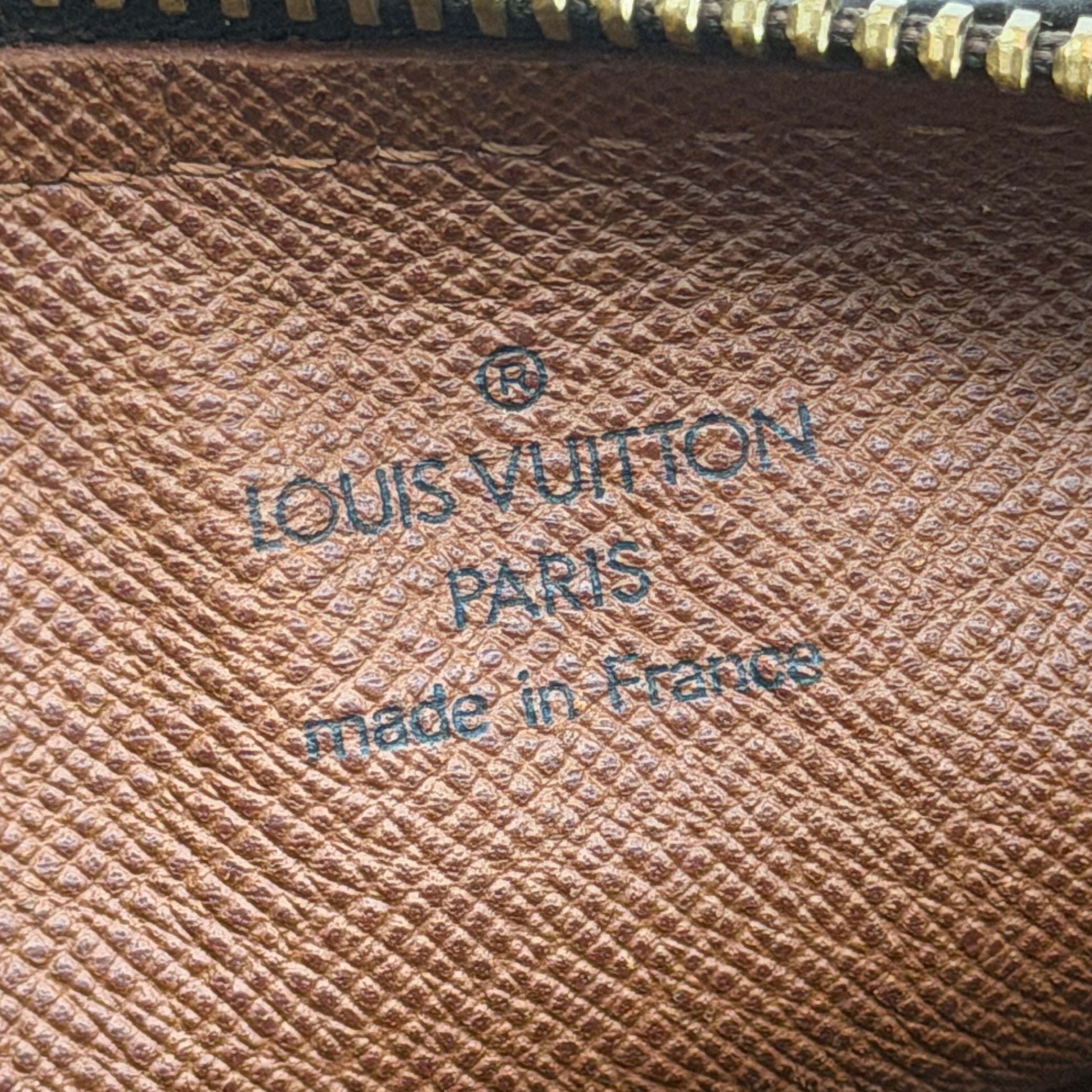 Louis Vuitton Papillon 26 in Monogram canvas with brown leather trim and gold-tone zip, shown against a white background.