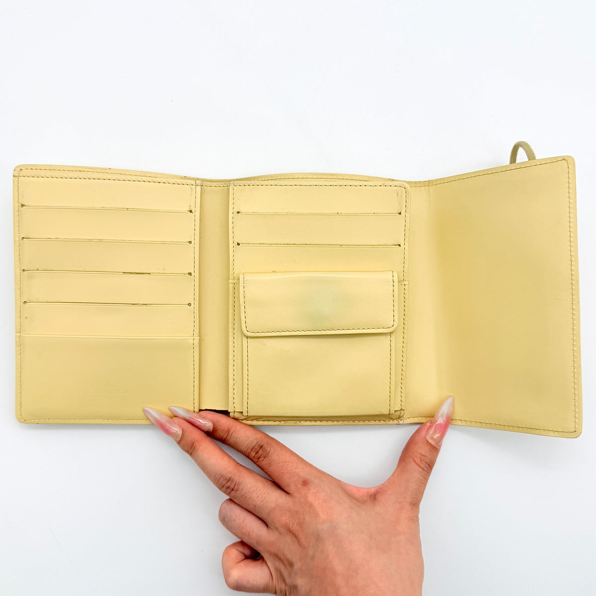 Louis Vuitton Epi Portefeuille Élastique Trifold Wallet in Vanilla Cream with dust bag, presented against a clean white background.