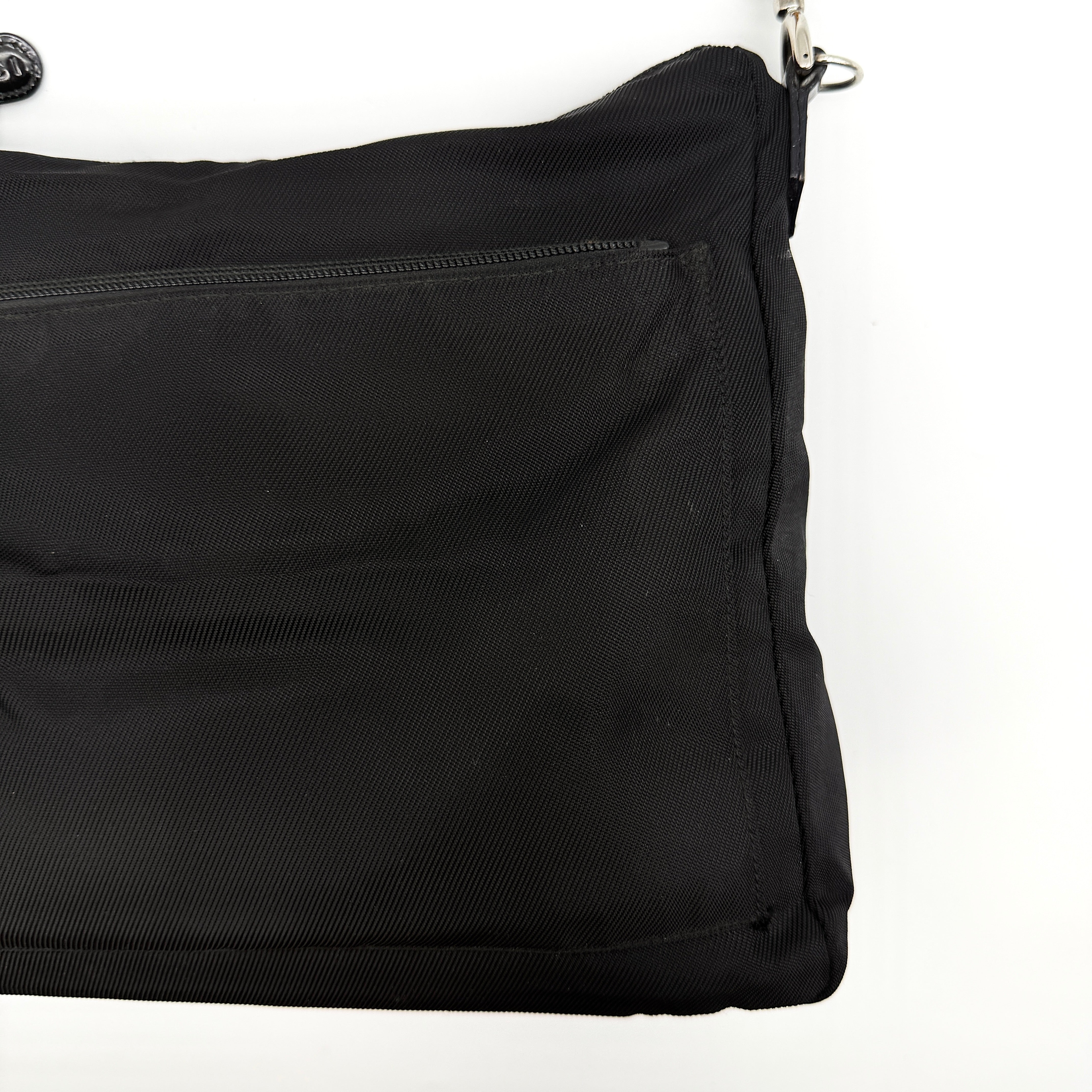 Gucci nylon shoulder bag in black with bamboo handle, shown against a white background.