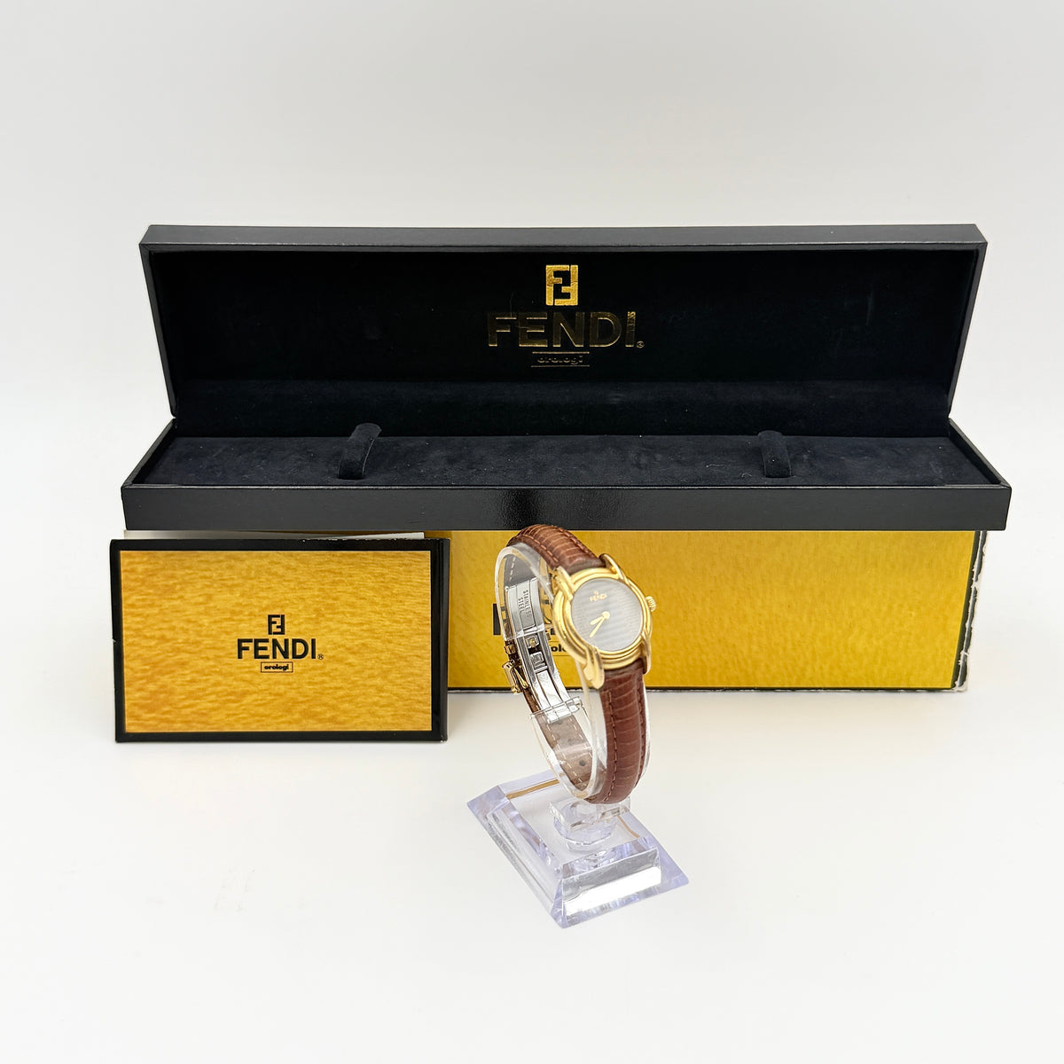 Fendi 350L Orologi Quartz Watch in gold with brown leather strap, displayed with original box and booklet.