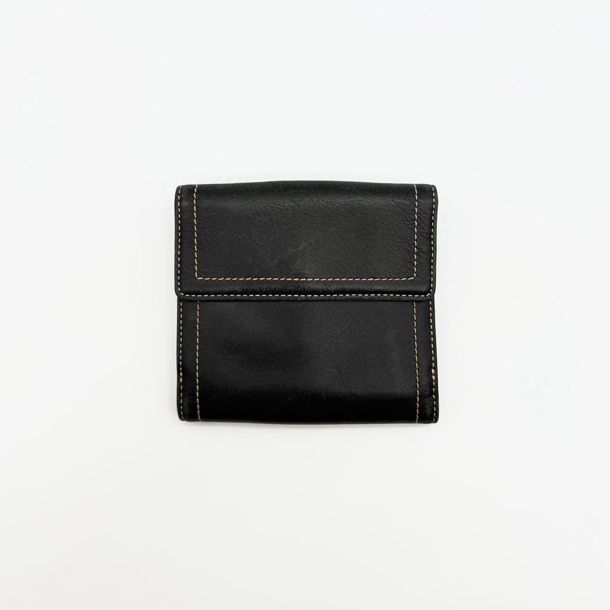 Coach black Soho Bifold Wallet with signature silver buckle and contrast stitching, shown closed against a white background.