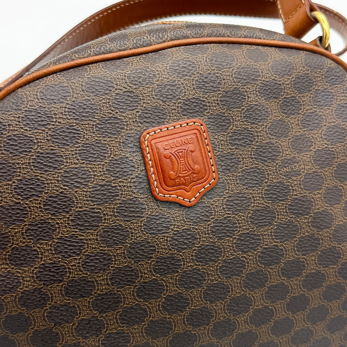 Front view of the Celine Triomphe Macadam Dome Handbag in brown, featuring the signature monogram canvas and tan leather details.