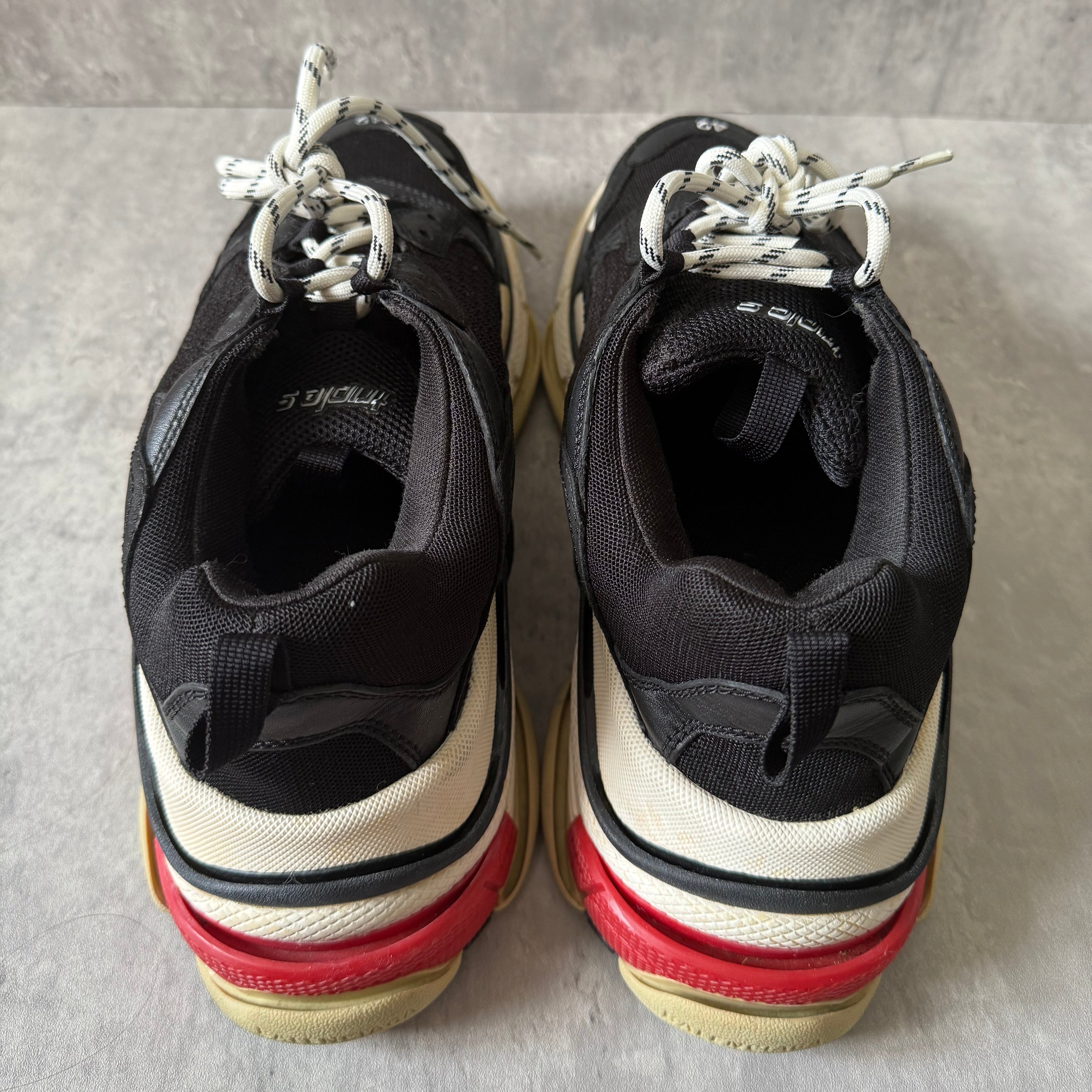 Balenciaga Triple S Black White Red sneakers, featuring layered mesh and leather upper, distressed sole, and oversized silhouette with embroidered size 42.