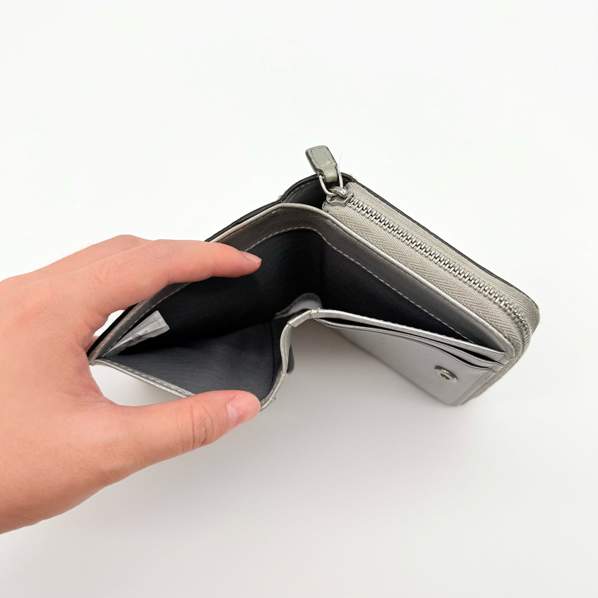 MCM Visetos Monogram wallet in metallic silver with black logo pattern on a clean white background.