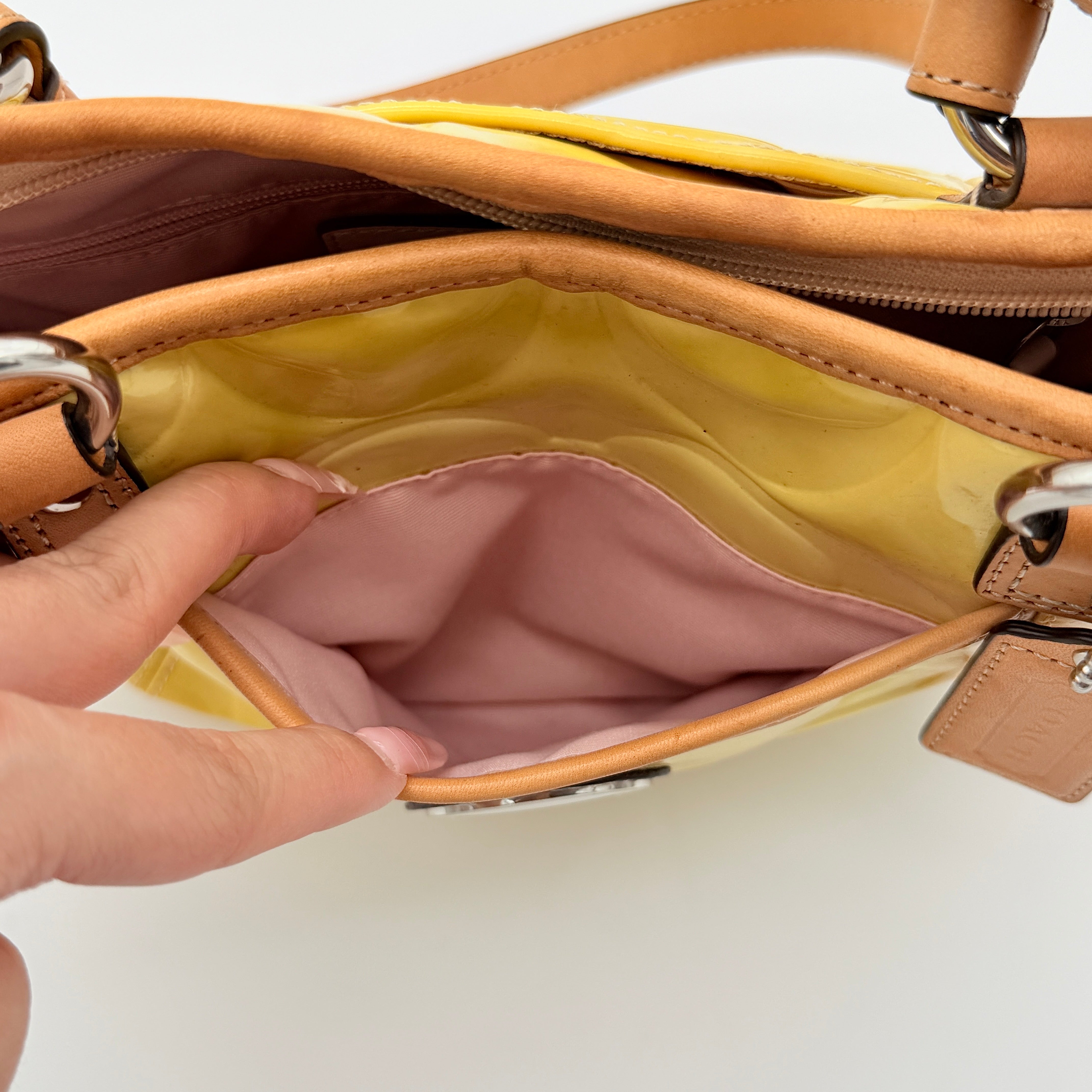 Coach Peyton tote in glossy yellow patent leather with tan handles and detachable strap, shown with blush pink interior.